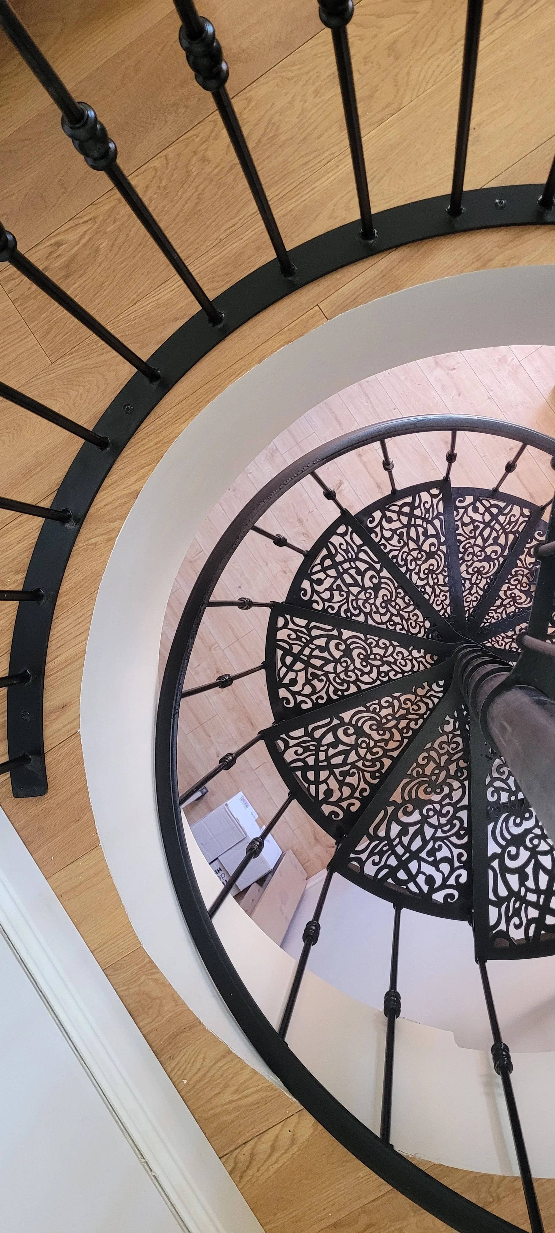 Escalier en colimaçon avec garde-corps noir décoratif et marches en découpe laser, style art déco à Toulon