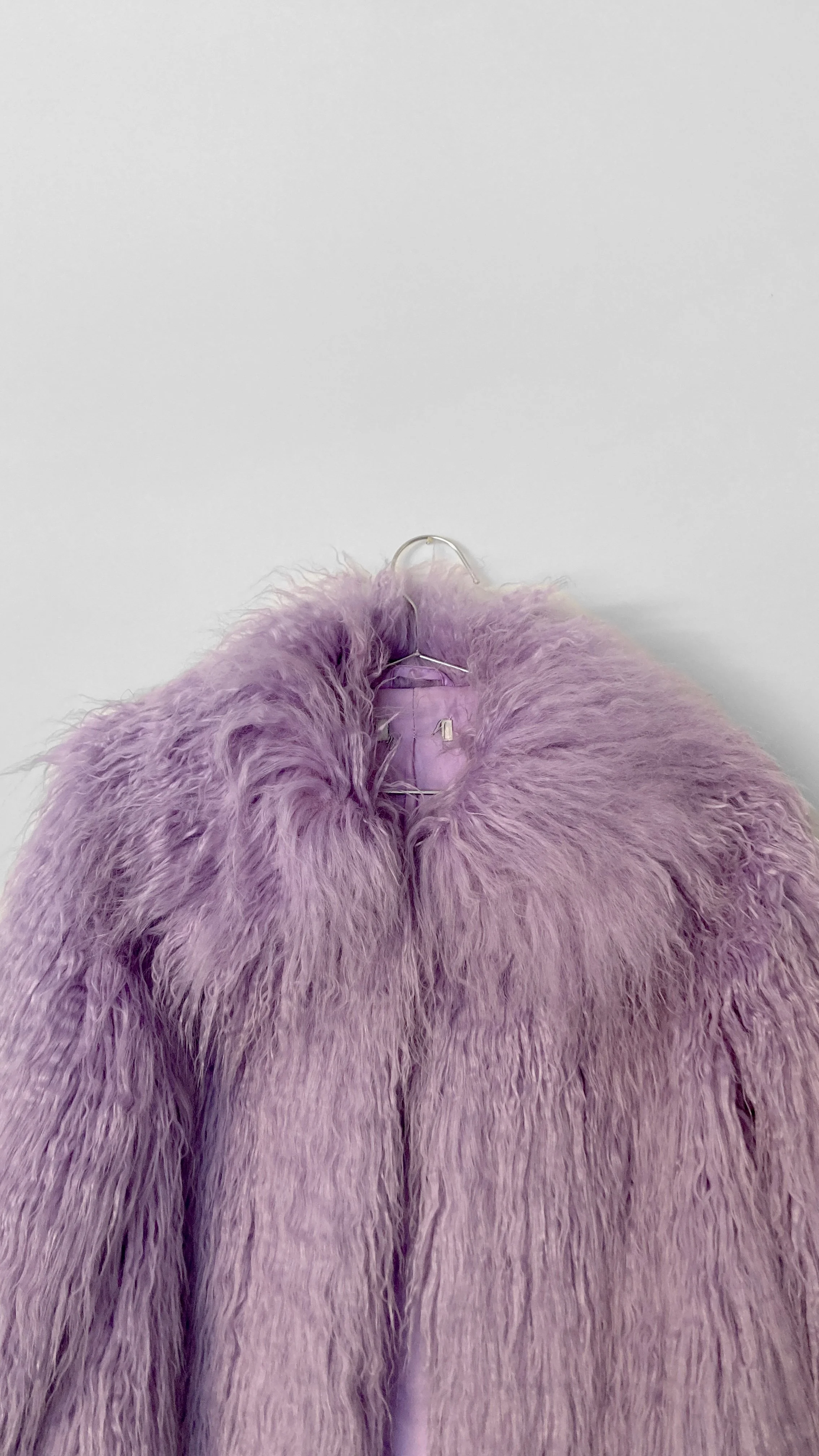 Close up image of the oversized faux fur collar on a lavender coloured faux fur jacket.