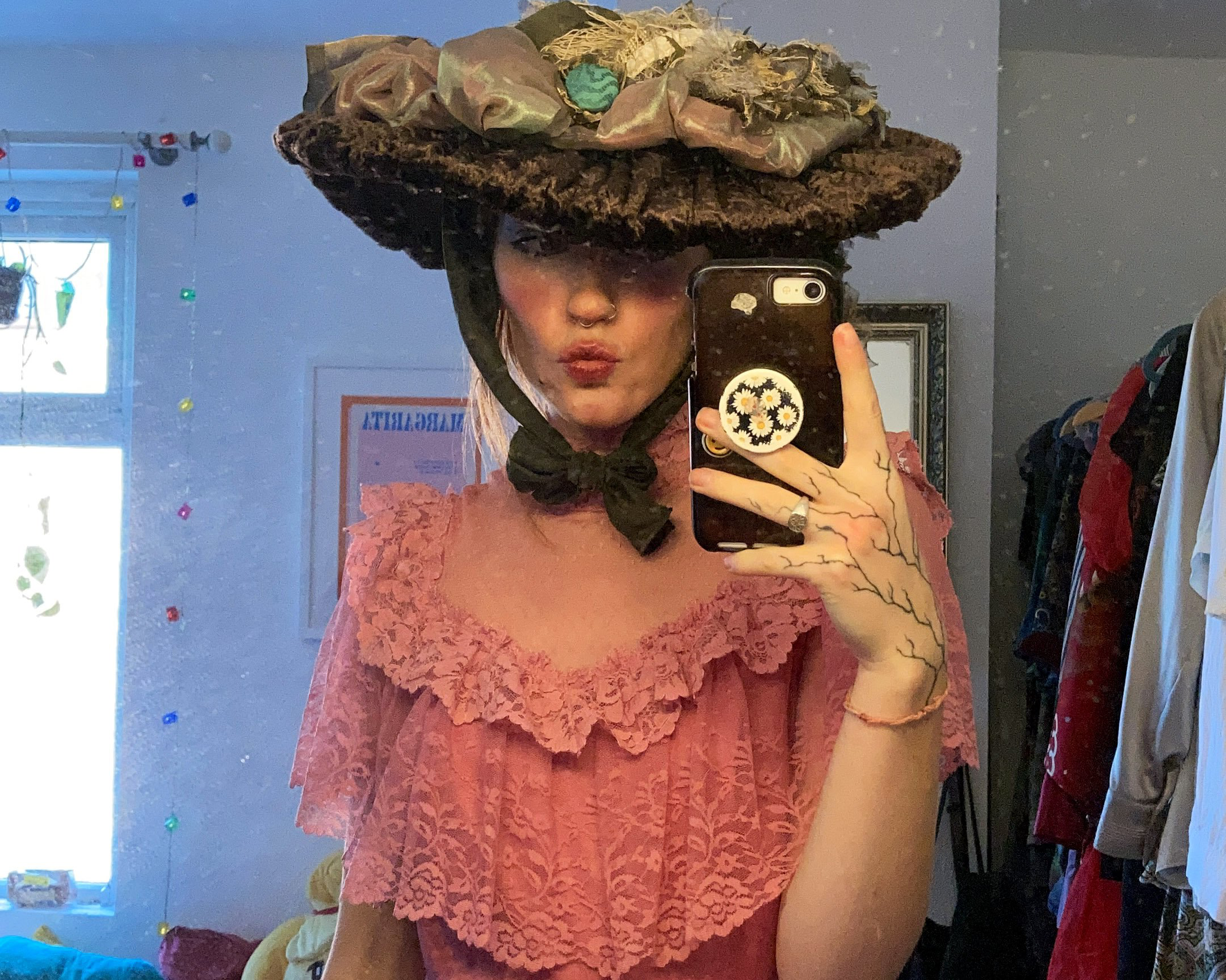 A girl poses in the rose pink floor length gown in front of a mirror. She is also wearing an Edwardian style hat, also made by Phoebe Niemira Costume Studio.