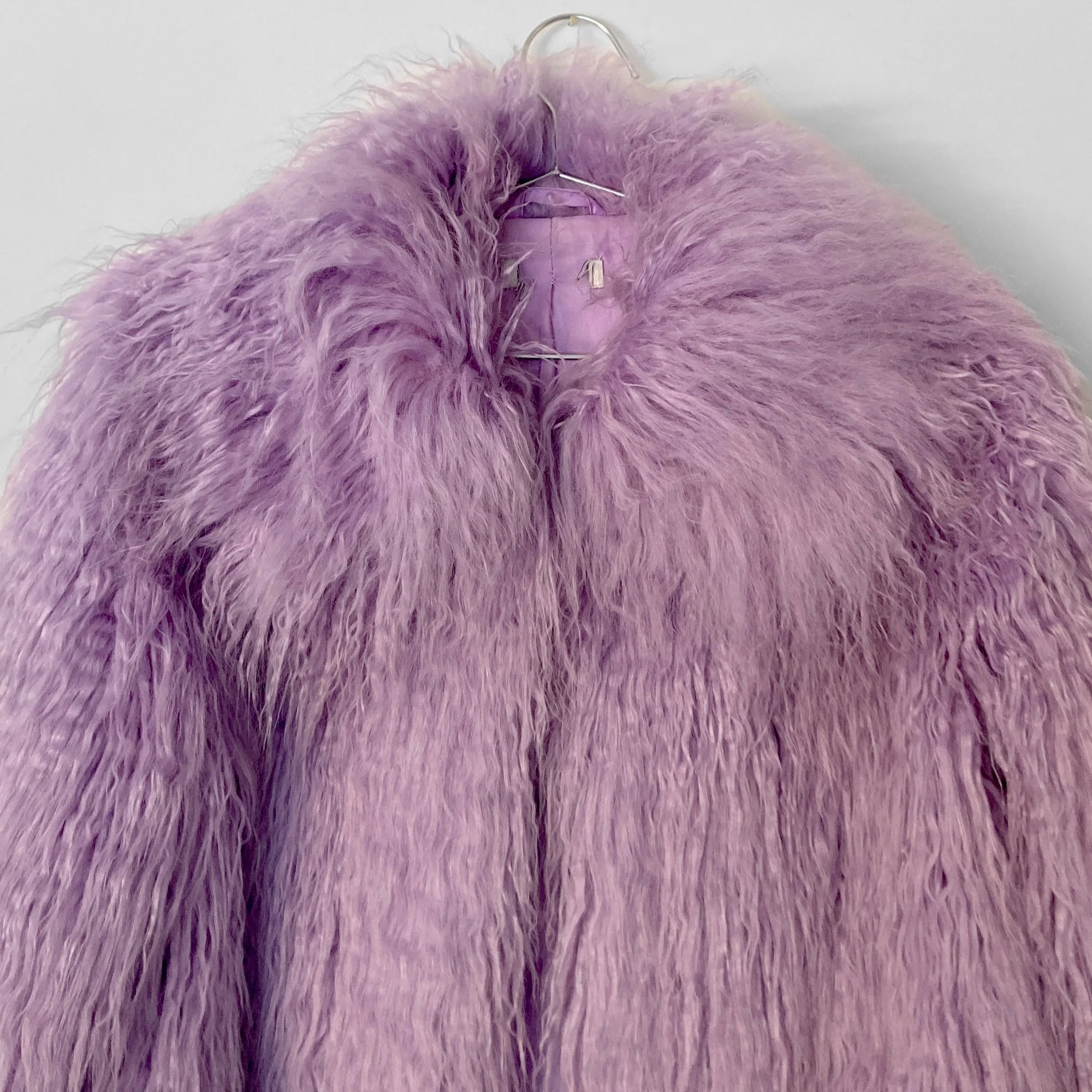 Close up image of the oversized faux fur collar on a lilac coloured faux fur jacket.
