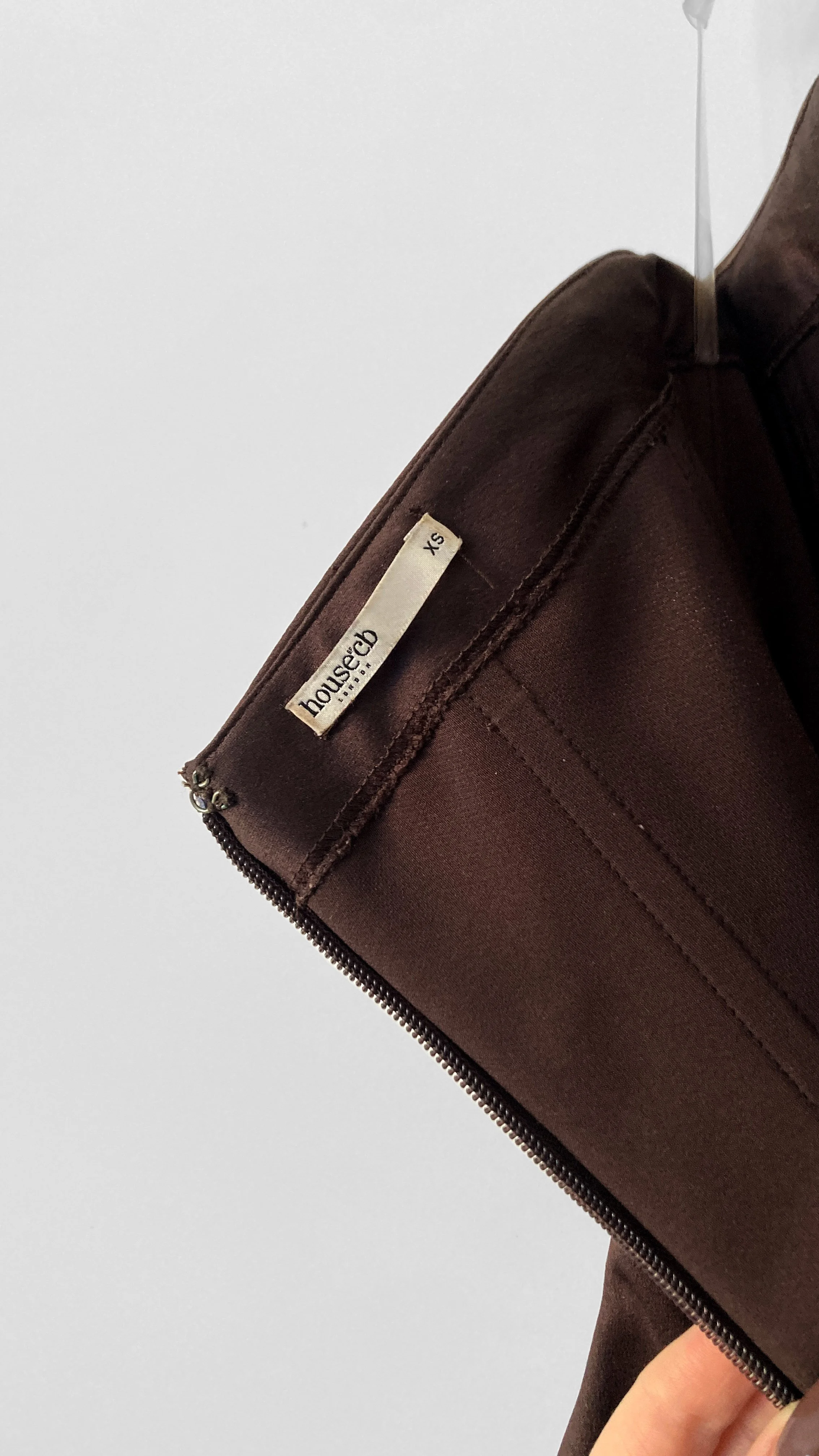 Close up internal view of the centre back zip closure, hook and eye, and "House of CB" label, that shows size "XS", in the chocolate mini cocktail dress.