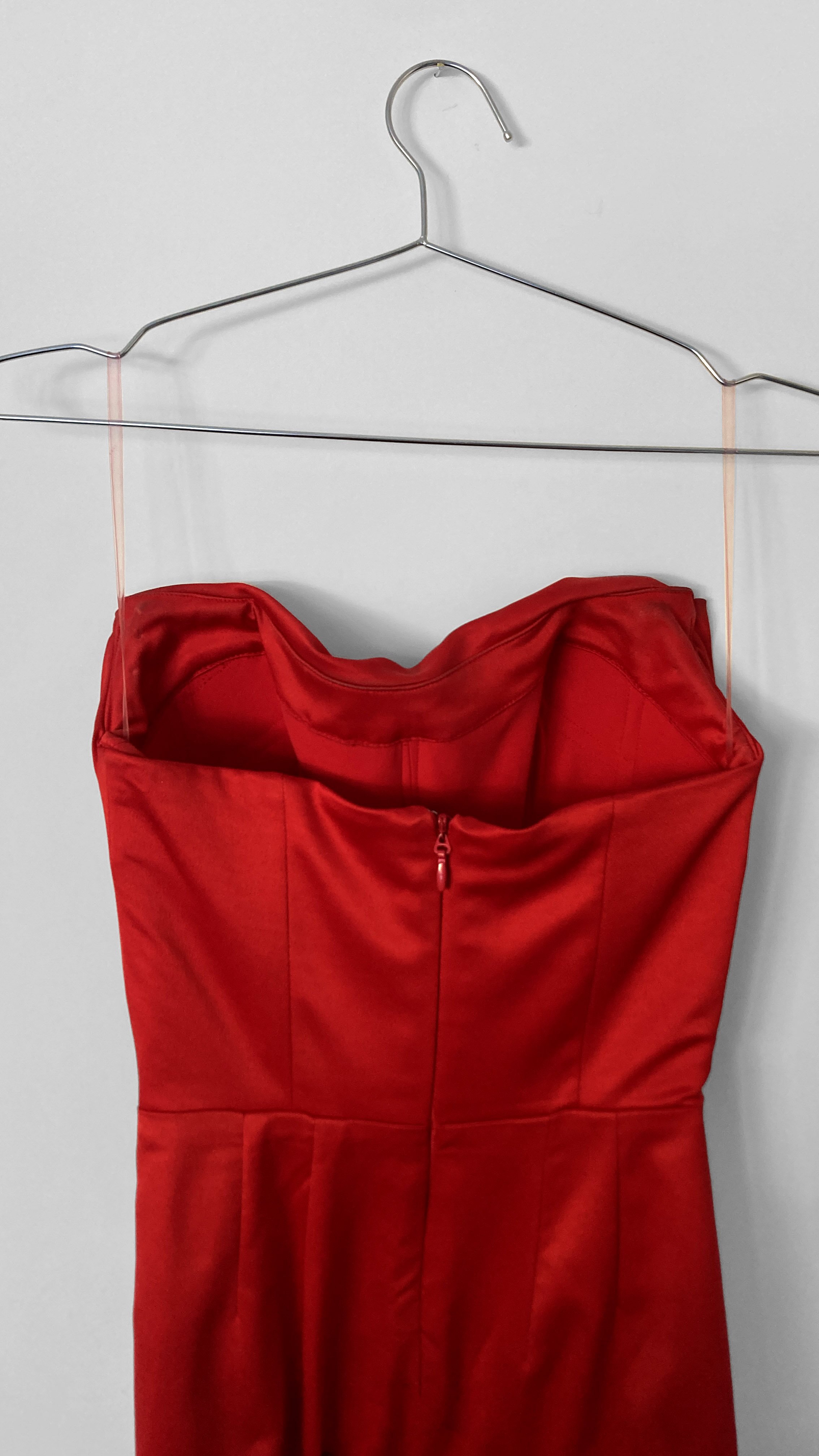 Close up back view of a classic strapless Hollywood red evening gown, with a centre back zip closure.