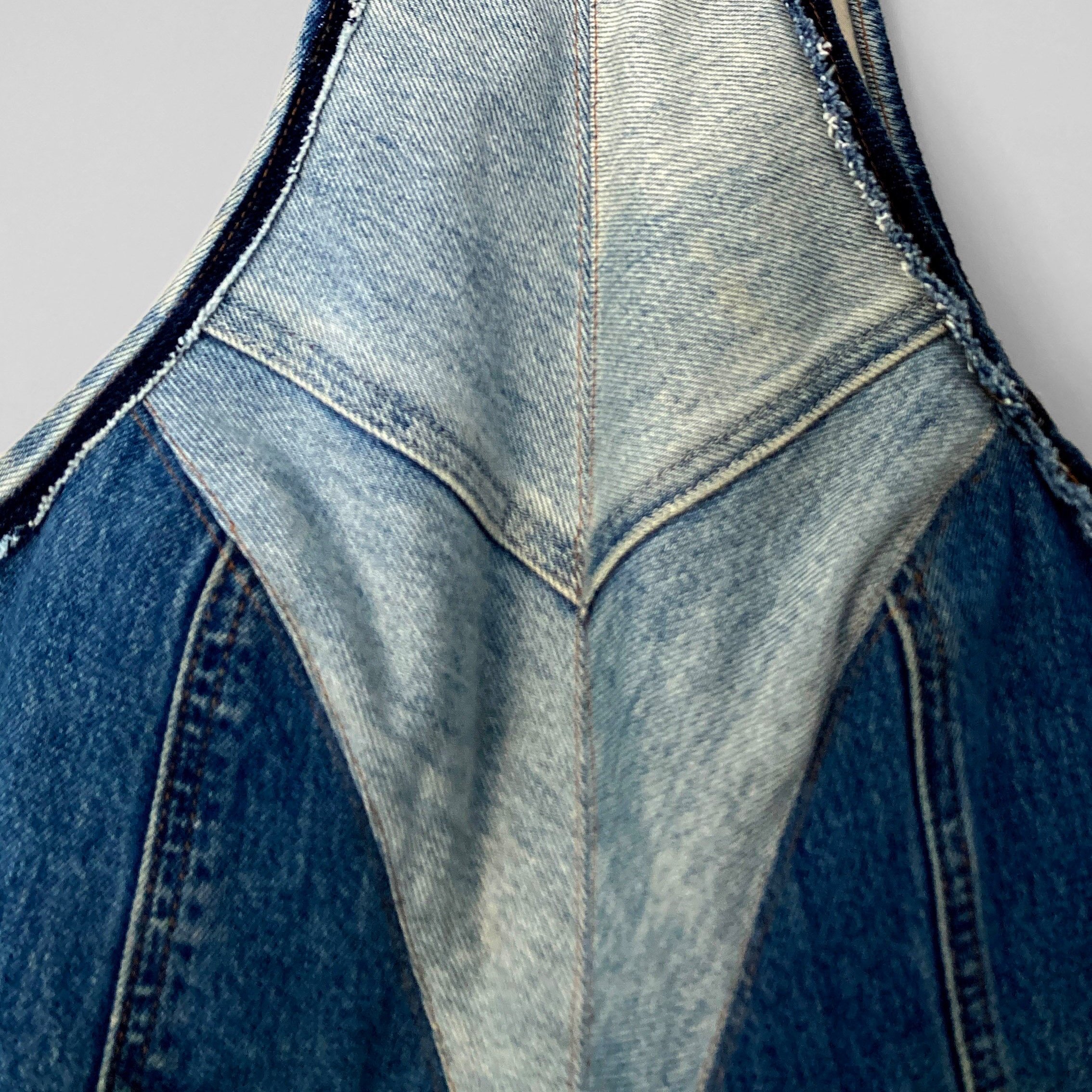 This image shows the denim boned bodice front details, including the decorative seams matching in the centre, and the raw, unwashed denim used as binding on the arm holes.