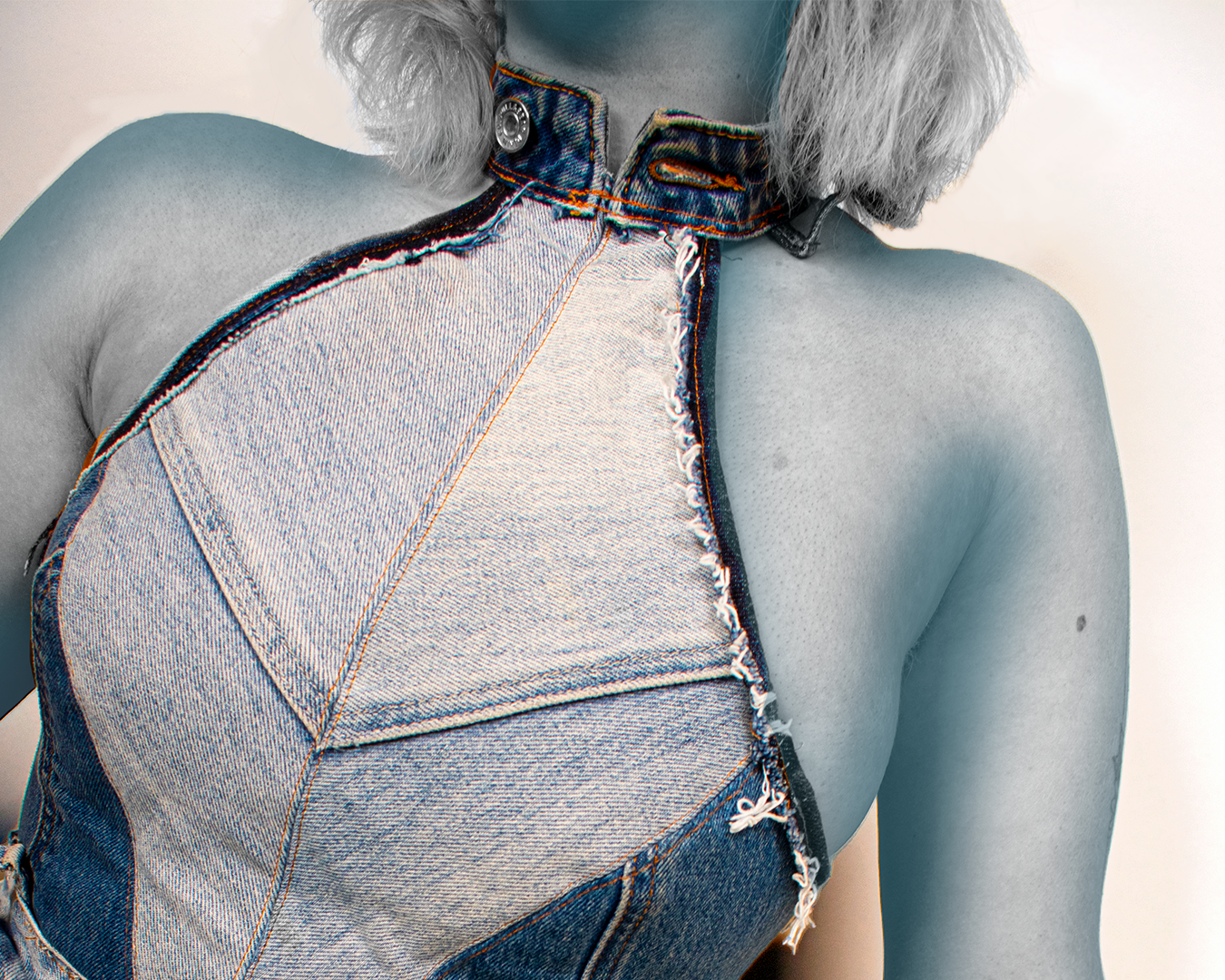 A close up of a bespoke to hire boned bodice, made from upcycled jeans. The image focuses on the front central seam and the collar, which is made from the waistband of a pair of jeans.