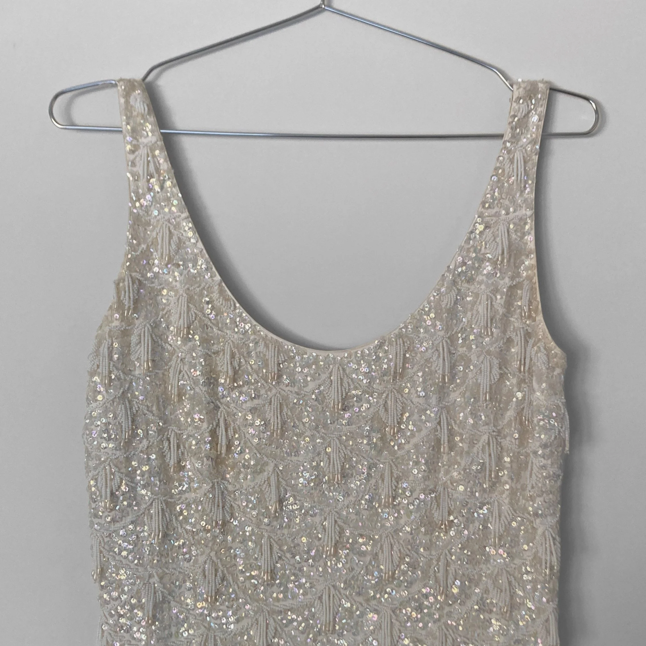 Close up image of the scoop neckline and straps of a handbeaded 1960s evening gown.