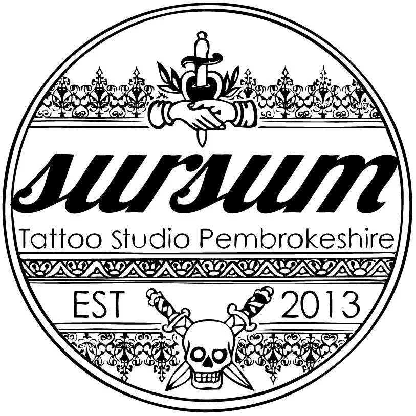 Circular logo for SURSUM Tattoo Studio Pembrokeshire, established in 2013, featuring a dagger and sword crossed behind a skull, surrounded by ornate patterns.