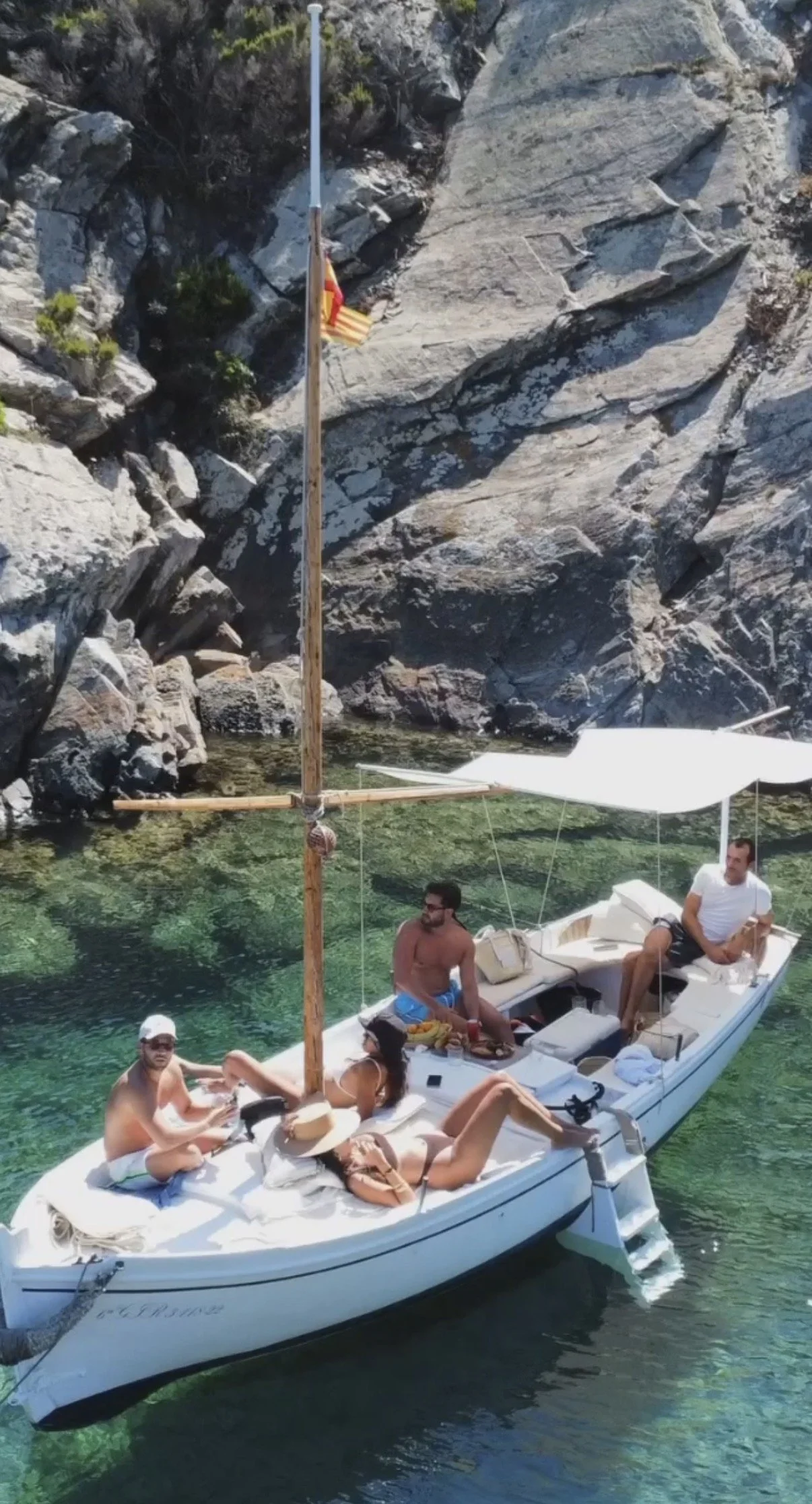 Bellamar boat anchored in a secluded cove with crystalline turquoise water in Cap de Creus Natural Park.