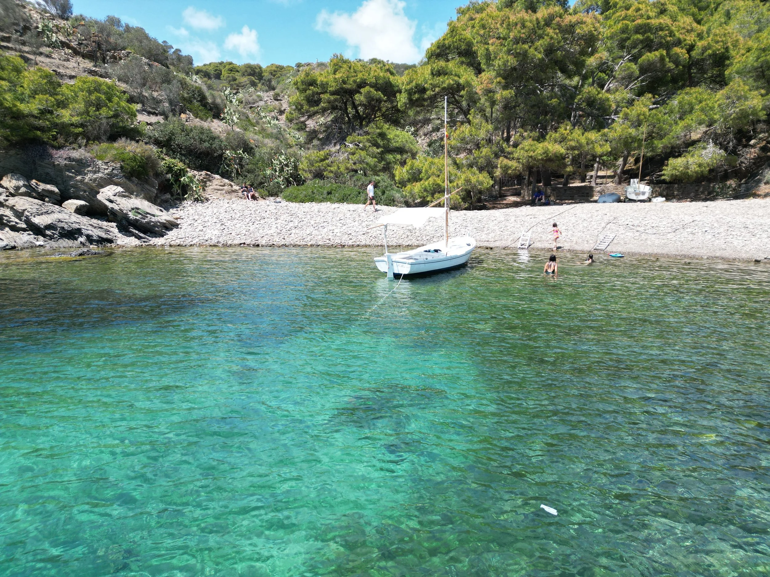 Bellamar boat anchored in a secluded cove with crystalline turquoise water in Cap de Creus Natural Park.