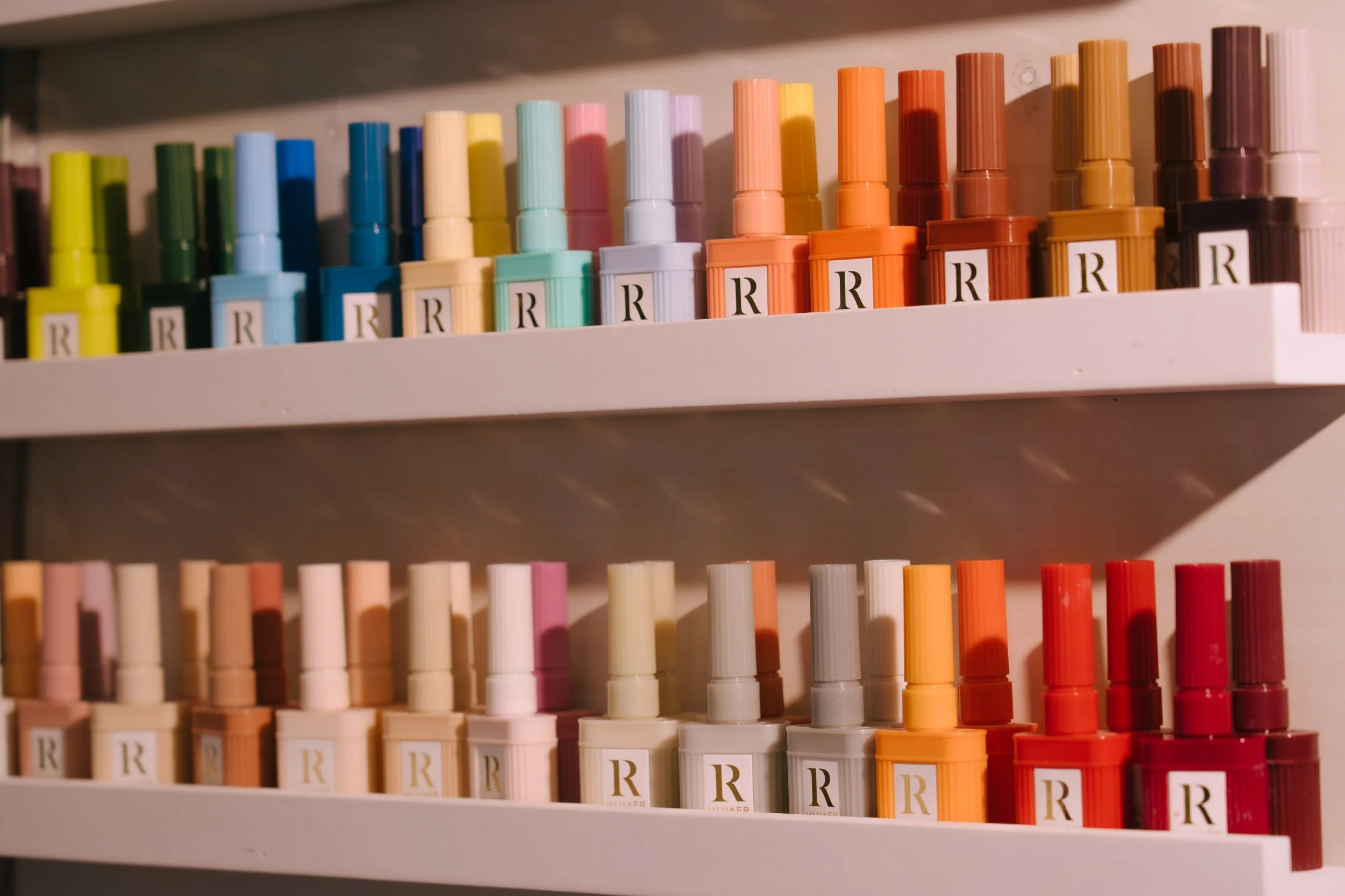 A curated display of gel nail color samples at Bangkok Lash Studio, featuring a wide selection of modern and classic shades.