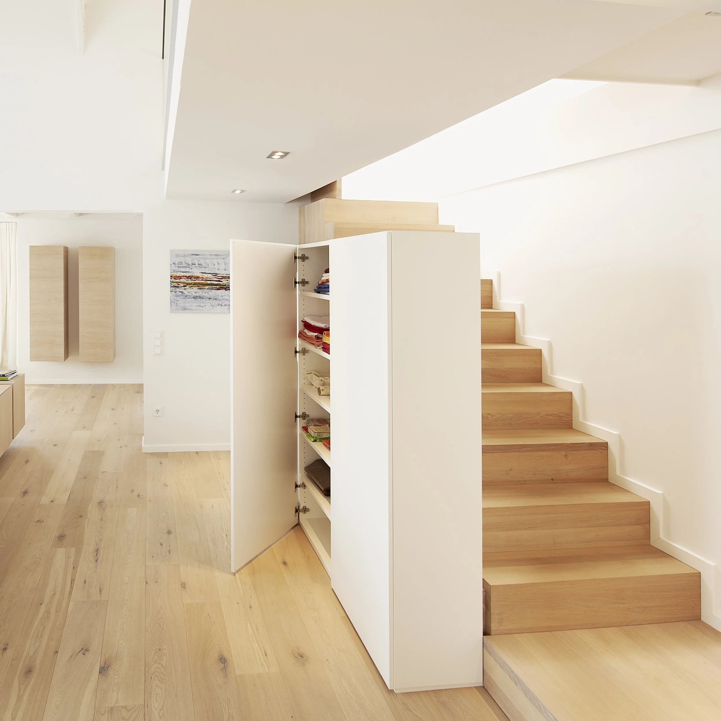 Moderne helle Wohnung mit offenen Räumen, Holzfußböden und Treppe