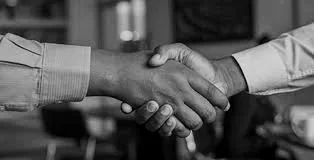 Close-up of two people shaking hands in a professional setting