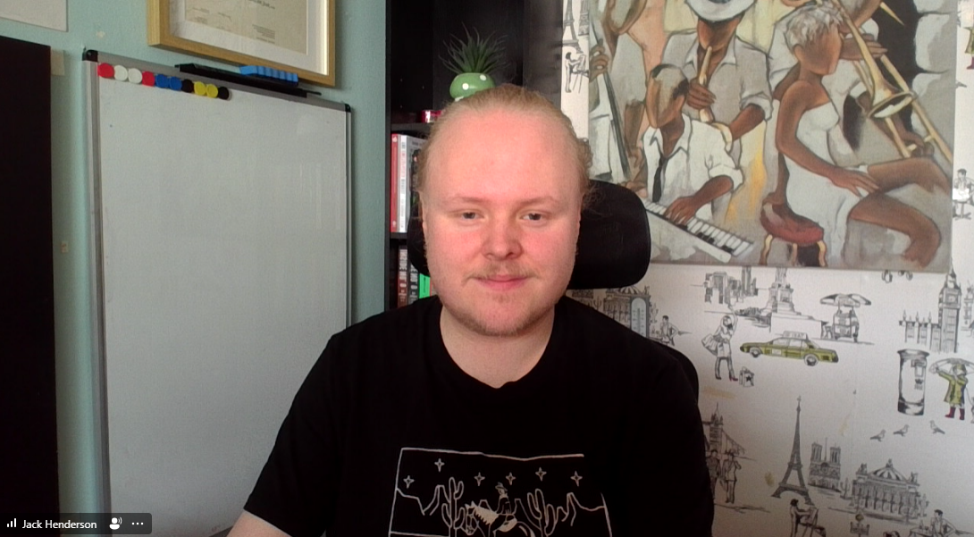 Therapist Jack Henderson in his virtual therapy space - with whiteboard, canvas and colourful wallpaper visible.