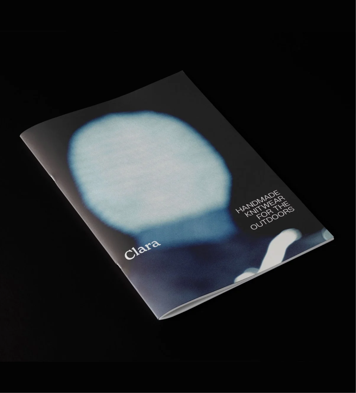 A zine cover with an abstract blue head shape and the logo 'Clara', 'Handmade Knitwear for the Outdoors'.