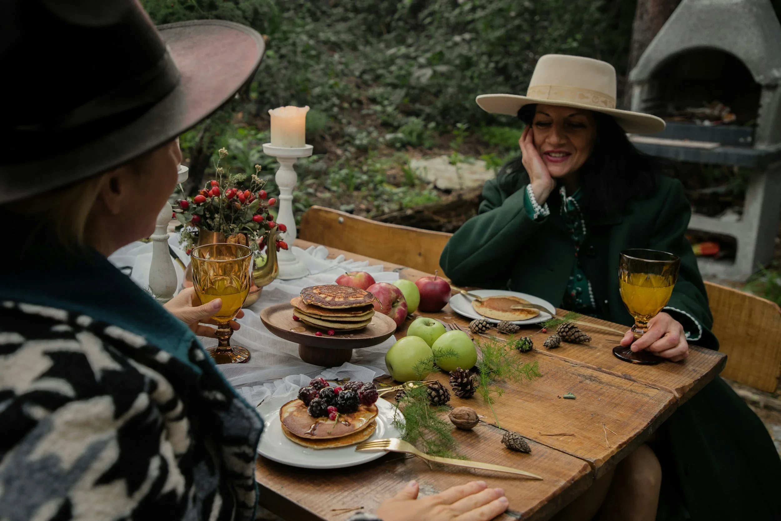 Two women having a serious conversation at an outdoor holiday breakfast table. PA therapist Mariah Zur helps clients navigate holiday stress and difficult family dynamics.