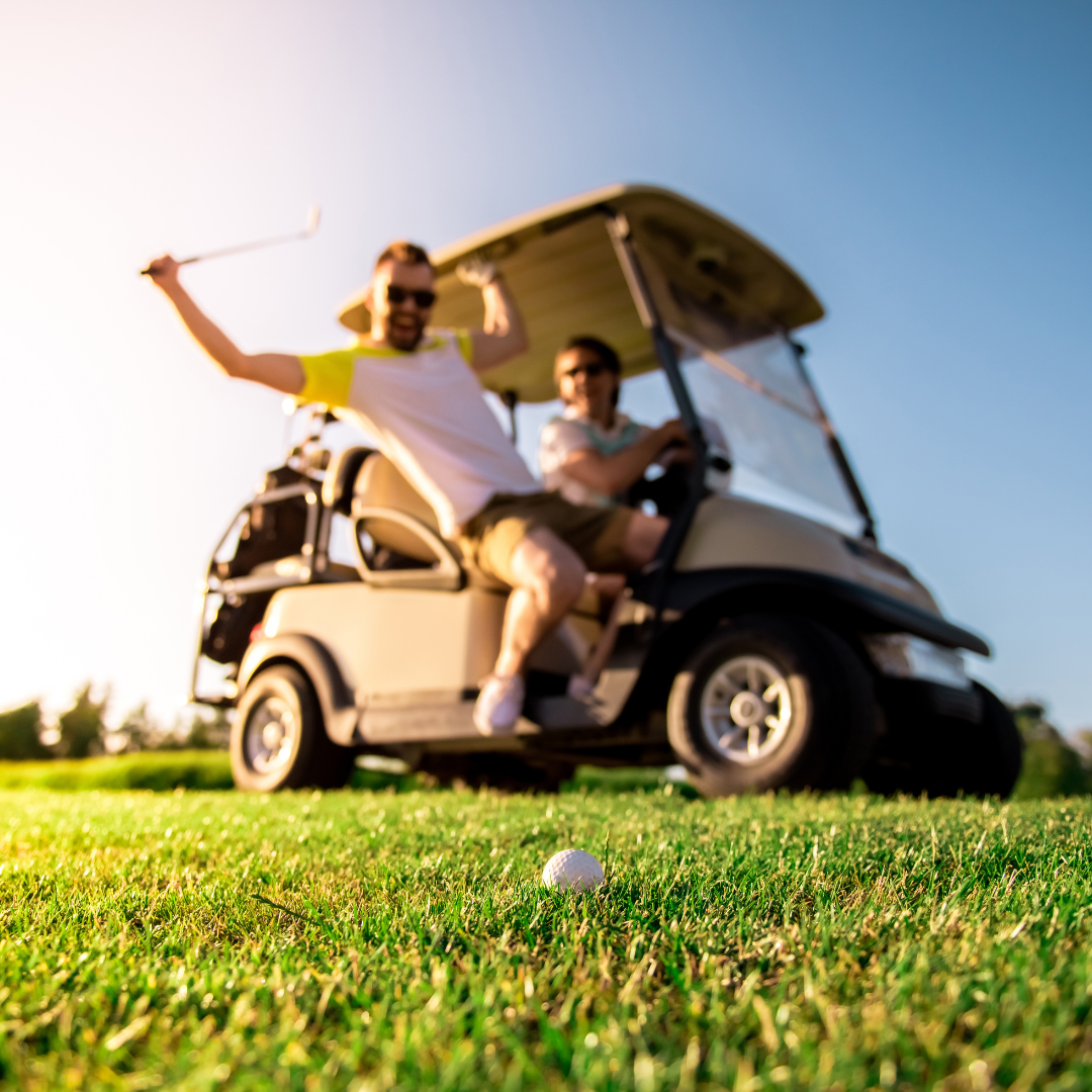 Two men on a golf cart in Pinehurst, North Carolina, representing the high-performance athletic community Mariah J. Zur serves for performance anxiety and the yips.
