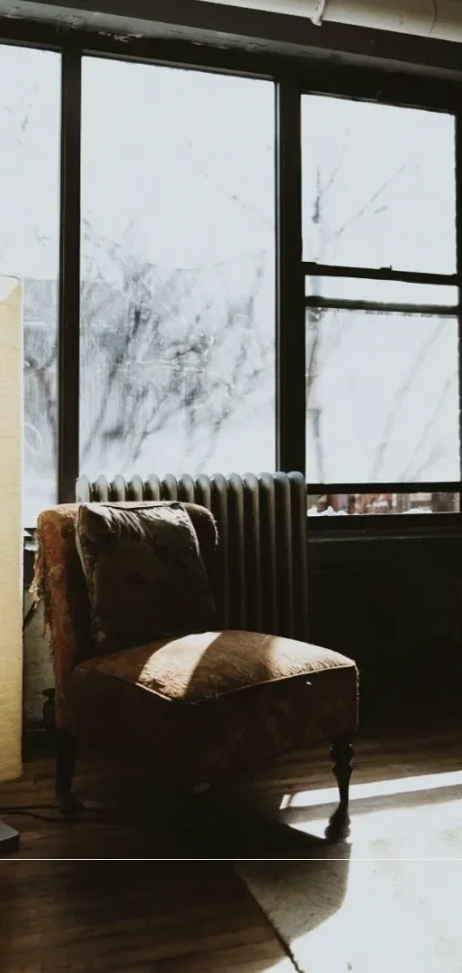 Cozy therapy space with a vintage chair beside a sunlit window.