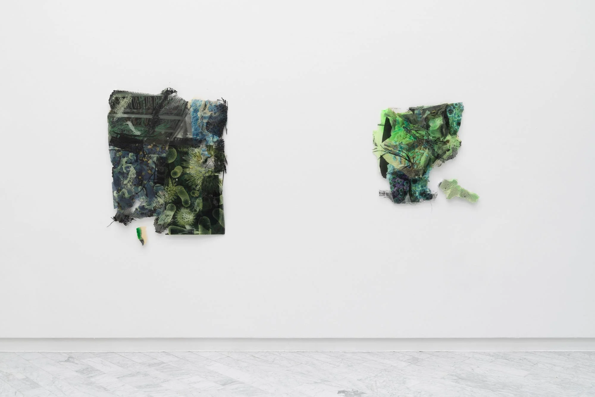 Two mixed media art pieces on a white gallery wall, utilizing torn paper, plastic, and textured materials with green, black, and blue hues.