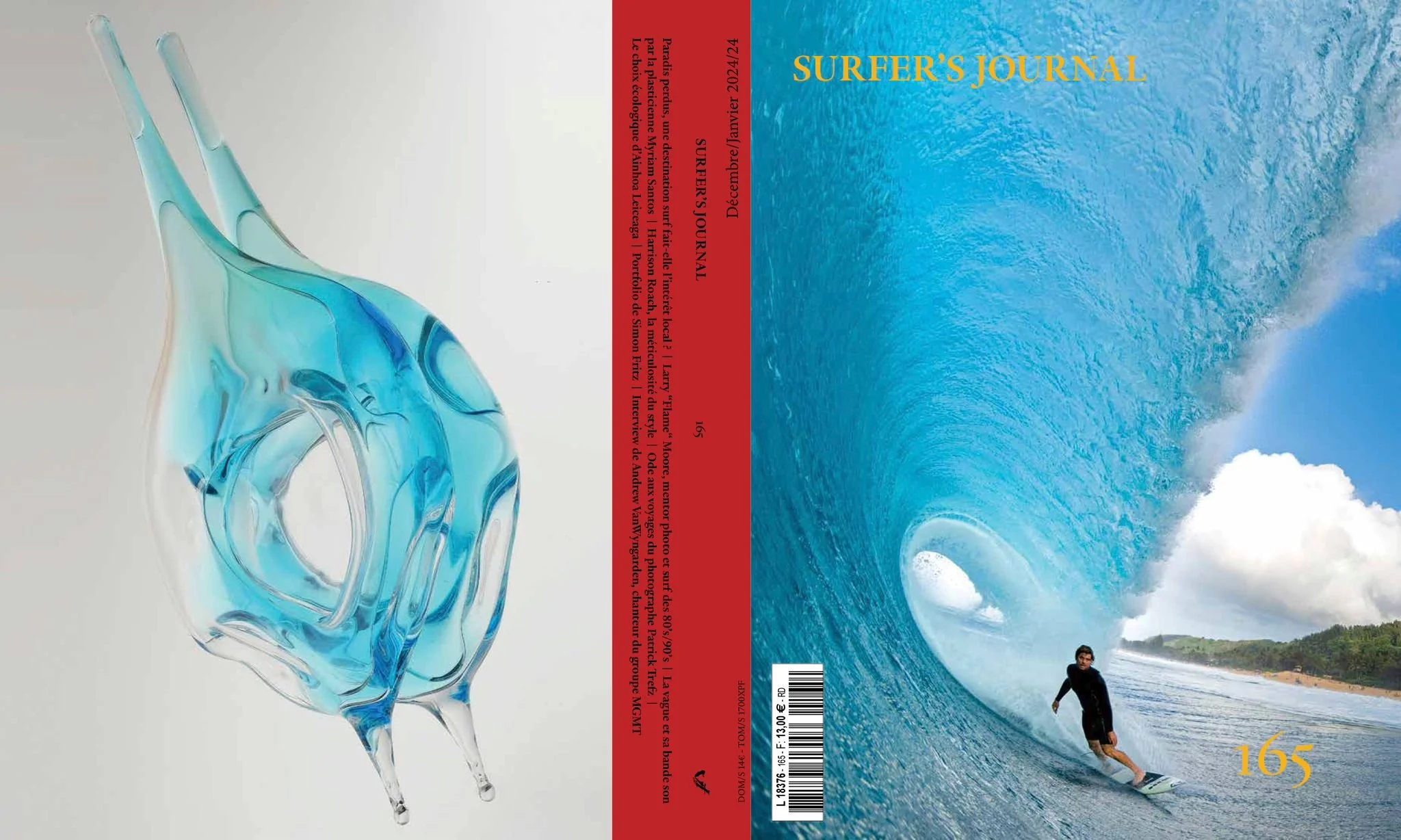 Cover of Surfer's Journal with a large ocean wave and a surfer riding it, and a glass sculpture resembling a wave in blue and teal on the left.