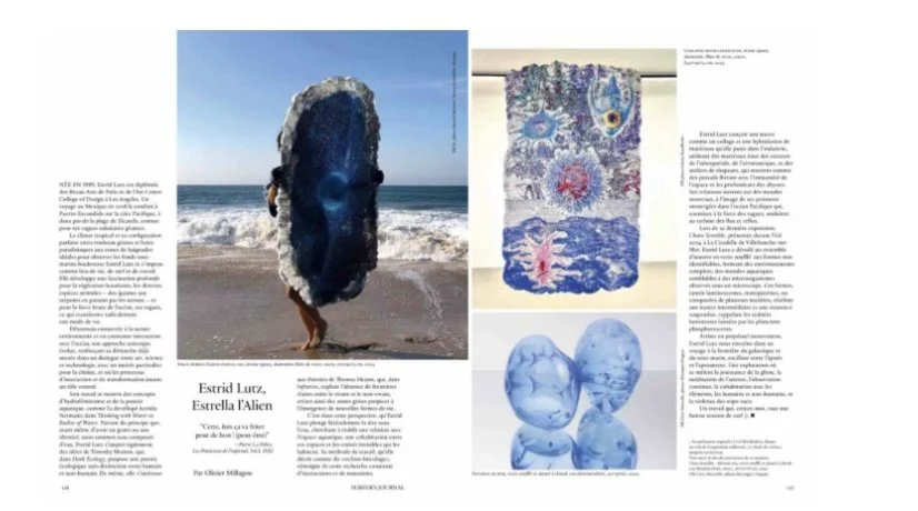 Page from a publication featuring an article about Estrid Larz and her artwork, including a large stone sculpture of a face on the beach, a textile piece with peacock feather design, and abstract blue glass sculptures.