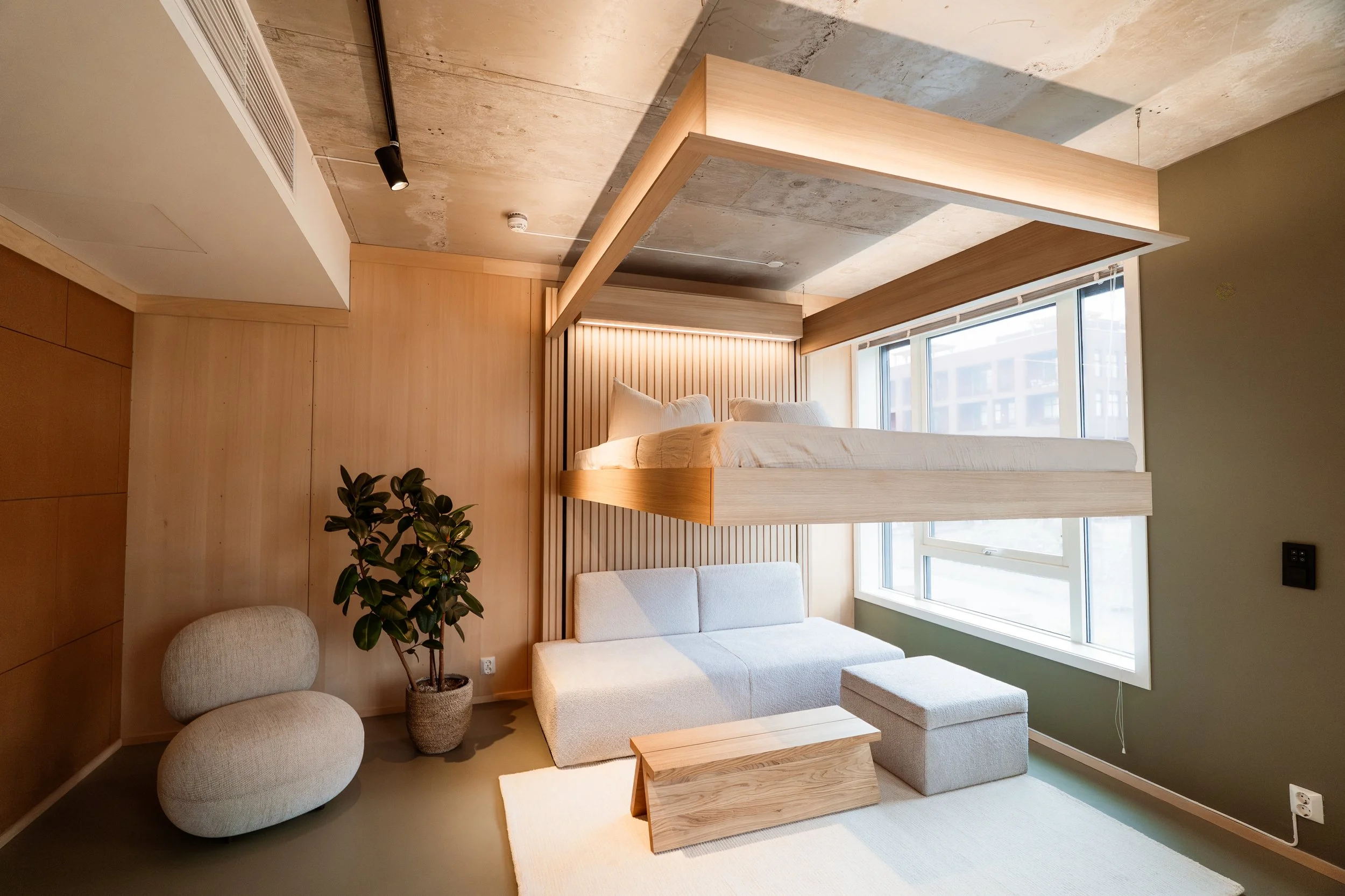 A MASE Bed installed with canopy, with the sofa and pouf below