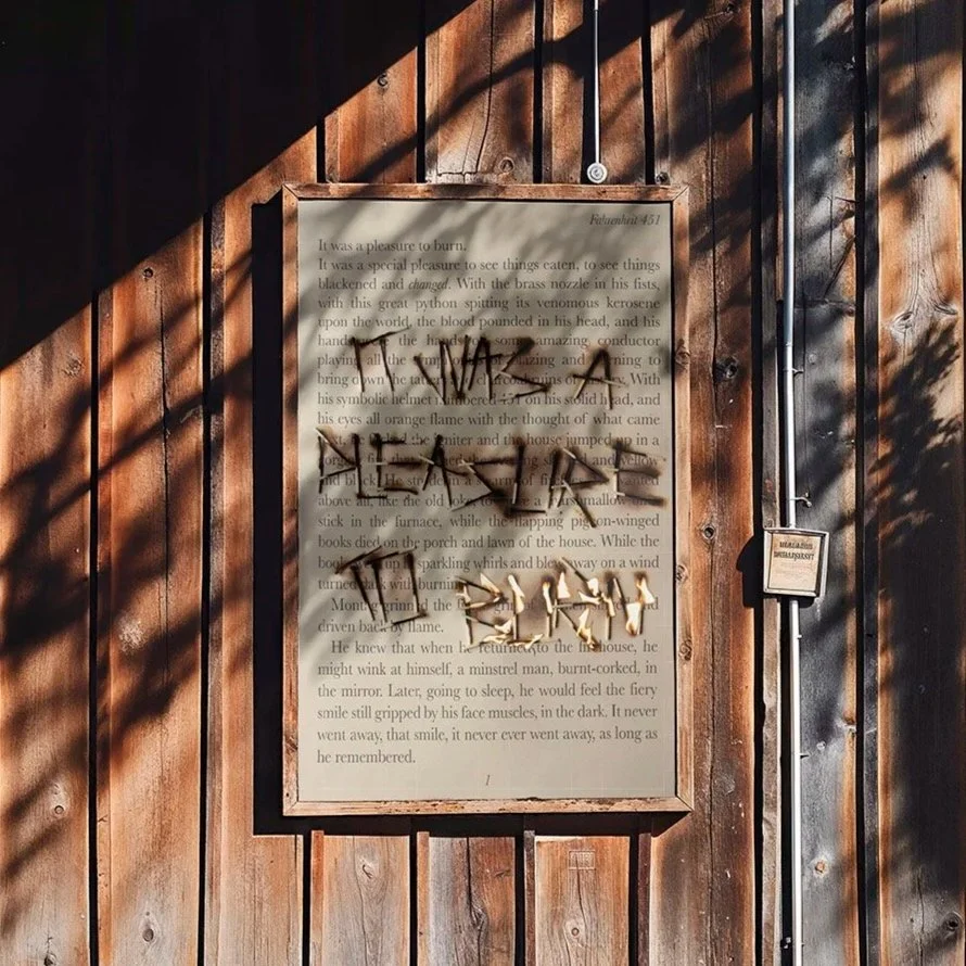 Une affiche en bois avec du texte en arrière-plan, partiellement masqué par des graffitis noirs et dorés sur un mur en bois, avec des ombres portées.