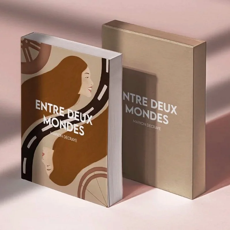 Deux livres à propos d'un voyage entre deux mondes, avec une couverture illustrée d'une femme aux cheveux longs et bouclés et un chemin qui traverse le visage, posés sur une surface rose pâle.