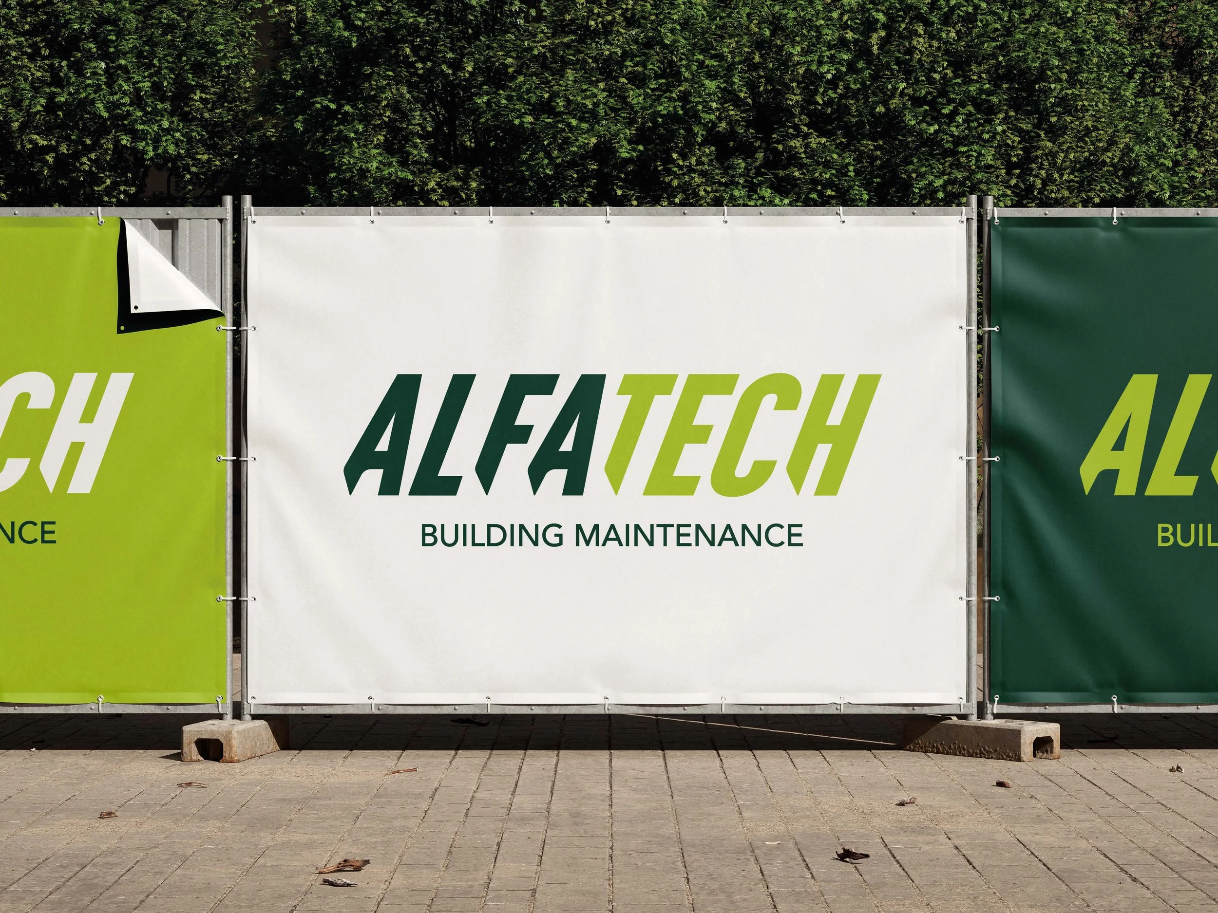 Panneaux publicitaires pour ALFATECH, une entreprise de maintenance de bâtiments, avec un fond de haies d'arbres et un sol pavé, en extérieur.