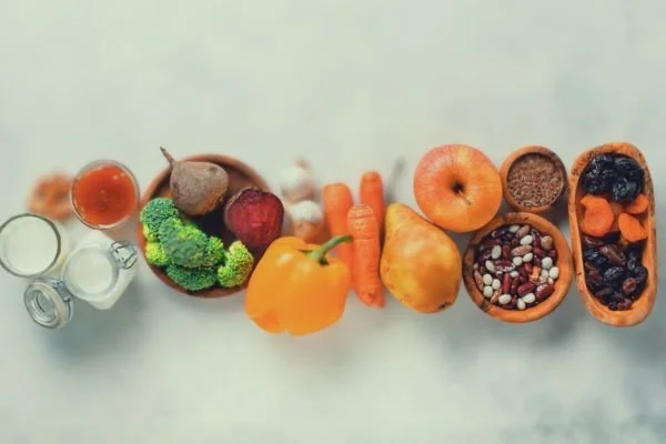 Healthy fibre rich foods including a pepper, carrots, pear, apple, beetroot and legumes to show food good for gut health. In a bubble shape to represent the gut.