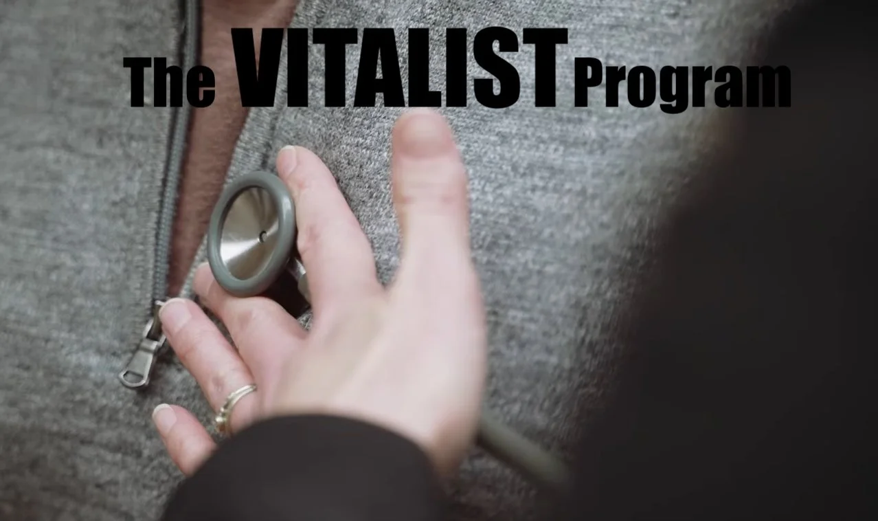 Close-up of a person with a stethoscope on their chest, wearing a gray knit sweater and a brown shirt, with the text 'The VITALIST Program' overlayed.