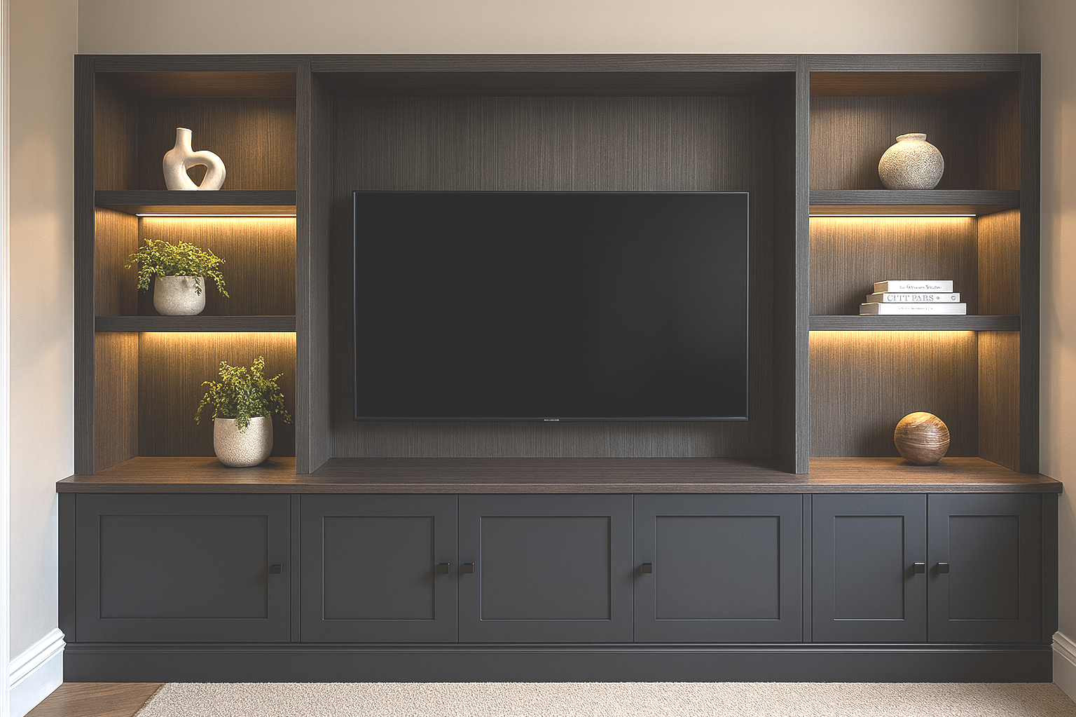 Modern entertainment center with a blank black TV, decorative vases, plants, and books, with built-in lighting.