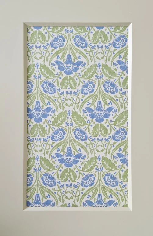Decorative wall panel with a floral pattern of blue flowers and green leaves.
