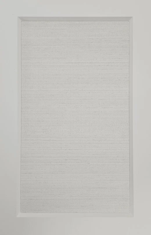 A white rectangular panel with a textured surface surrounded by a smooth white border.