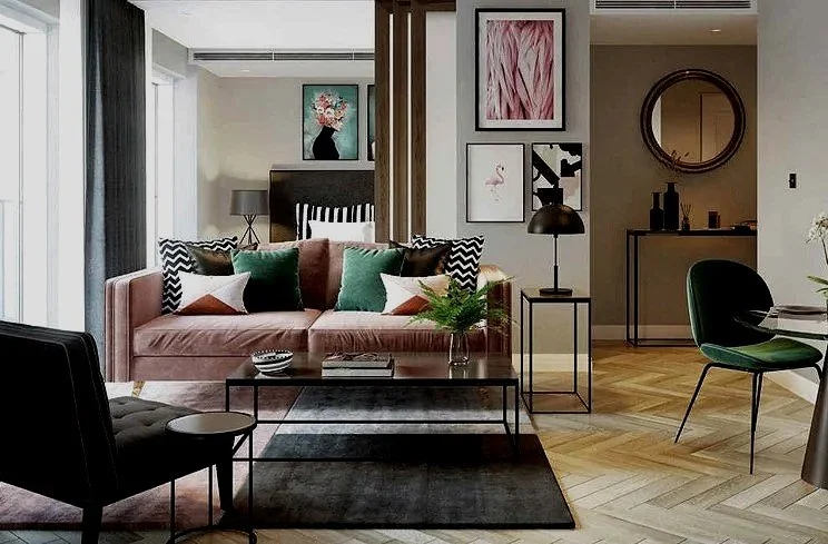 Modern living room with a pink velvet sofa, colorful throw pillows, a black armchair, a coffee table, and wall art.