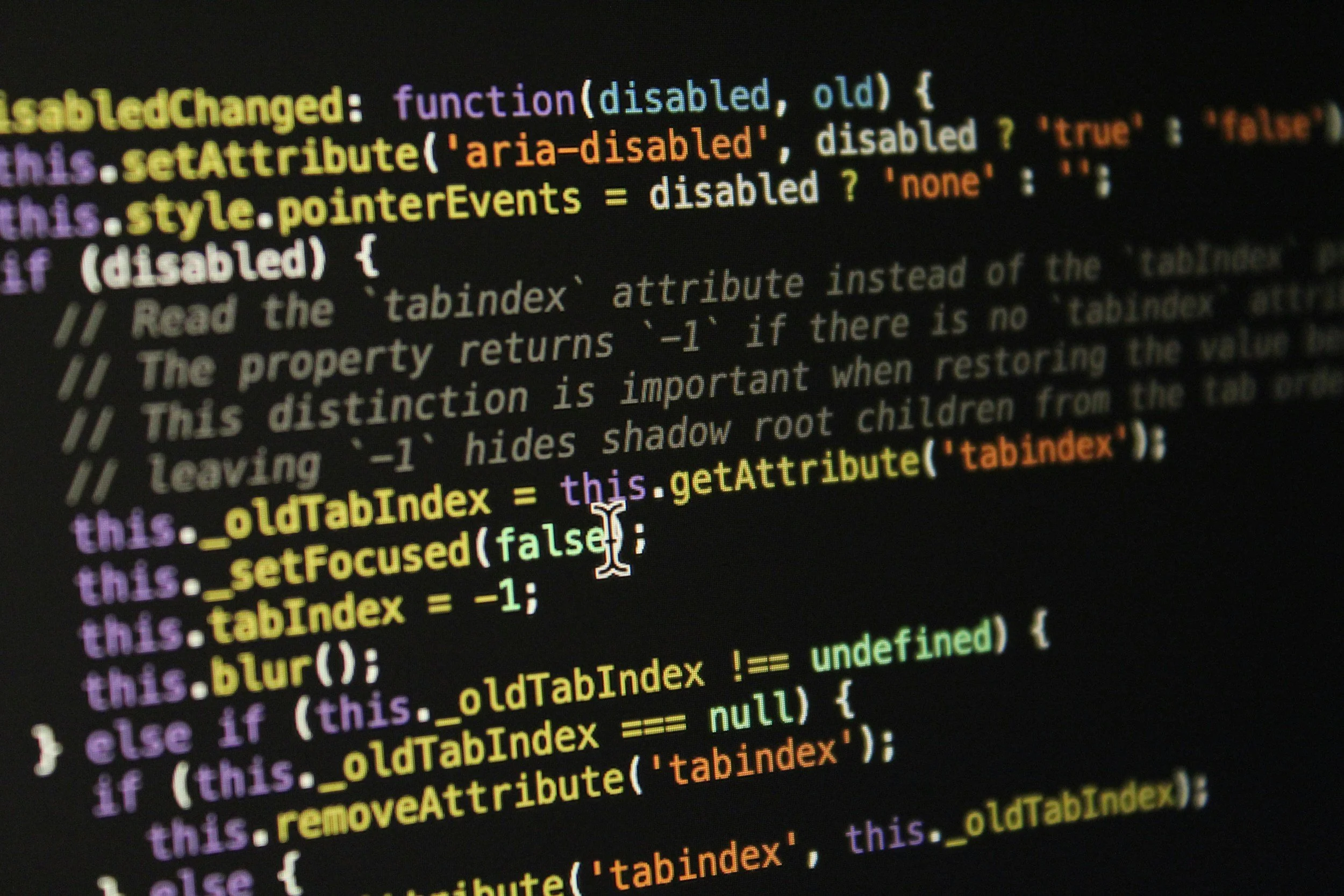 Close-up of computer code on a dark screen with multicolored syntax highlighting.