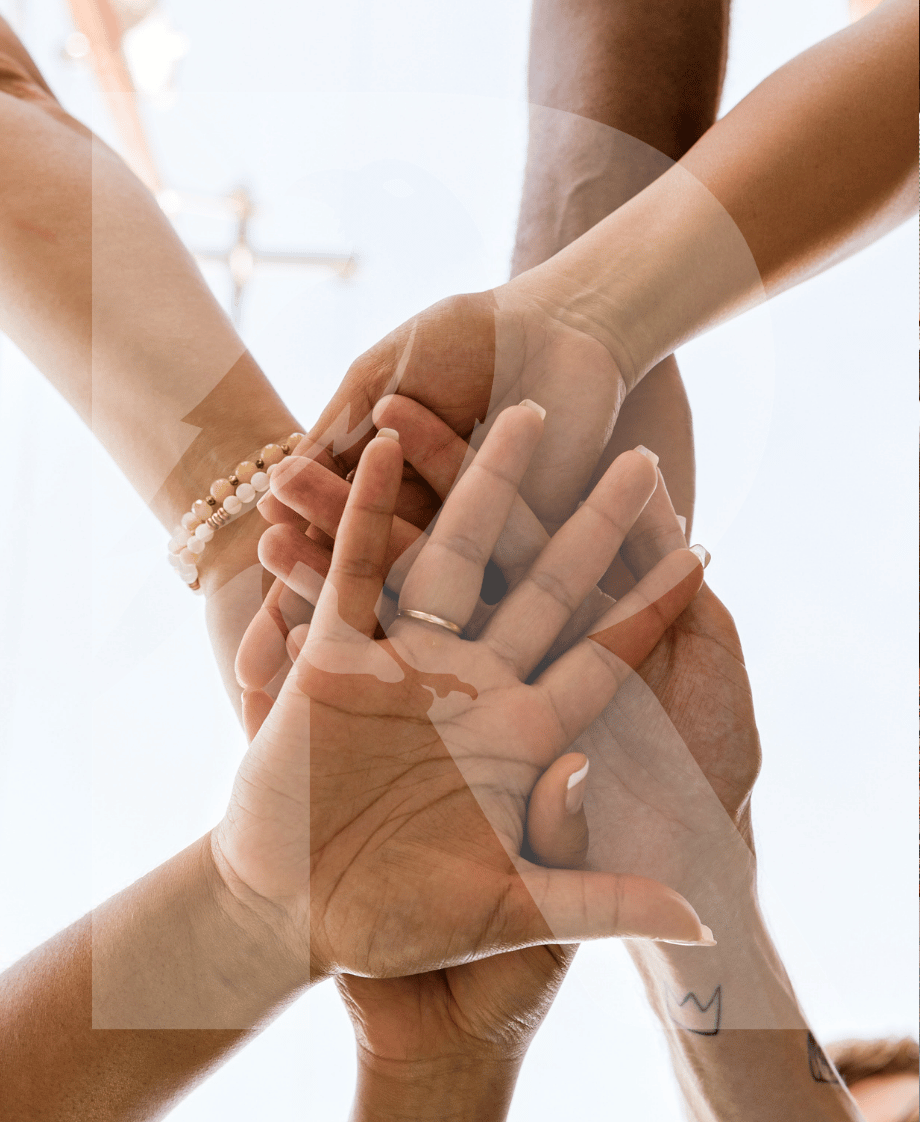 Mehrere Hände verschiedener Menschen, die sich in der Mitte berühren, symbolisieren Zusammenhalt und Gemeinschaft.