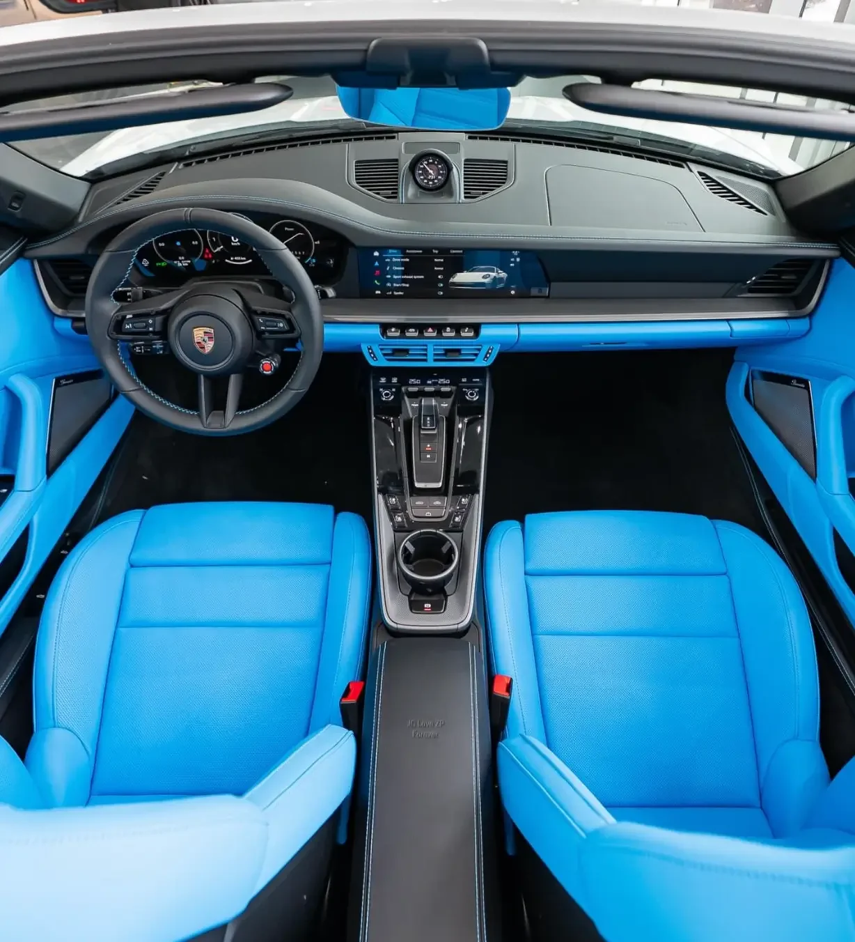 Porsche Sales Videos: Hochwertige Automotive-Innenraumaufnahme mit hellblauen Ledersitzen und modernem Cockpit.