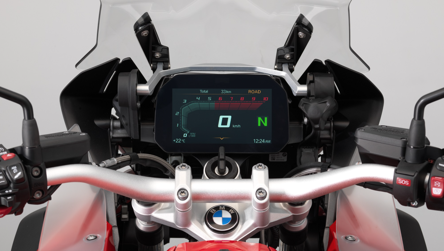 Digital display on a BMW motorcycle dashboard showing speed of 0 km/h, green 'N' for neutral gear, and a bar graph of 33 km total on the screen.