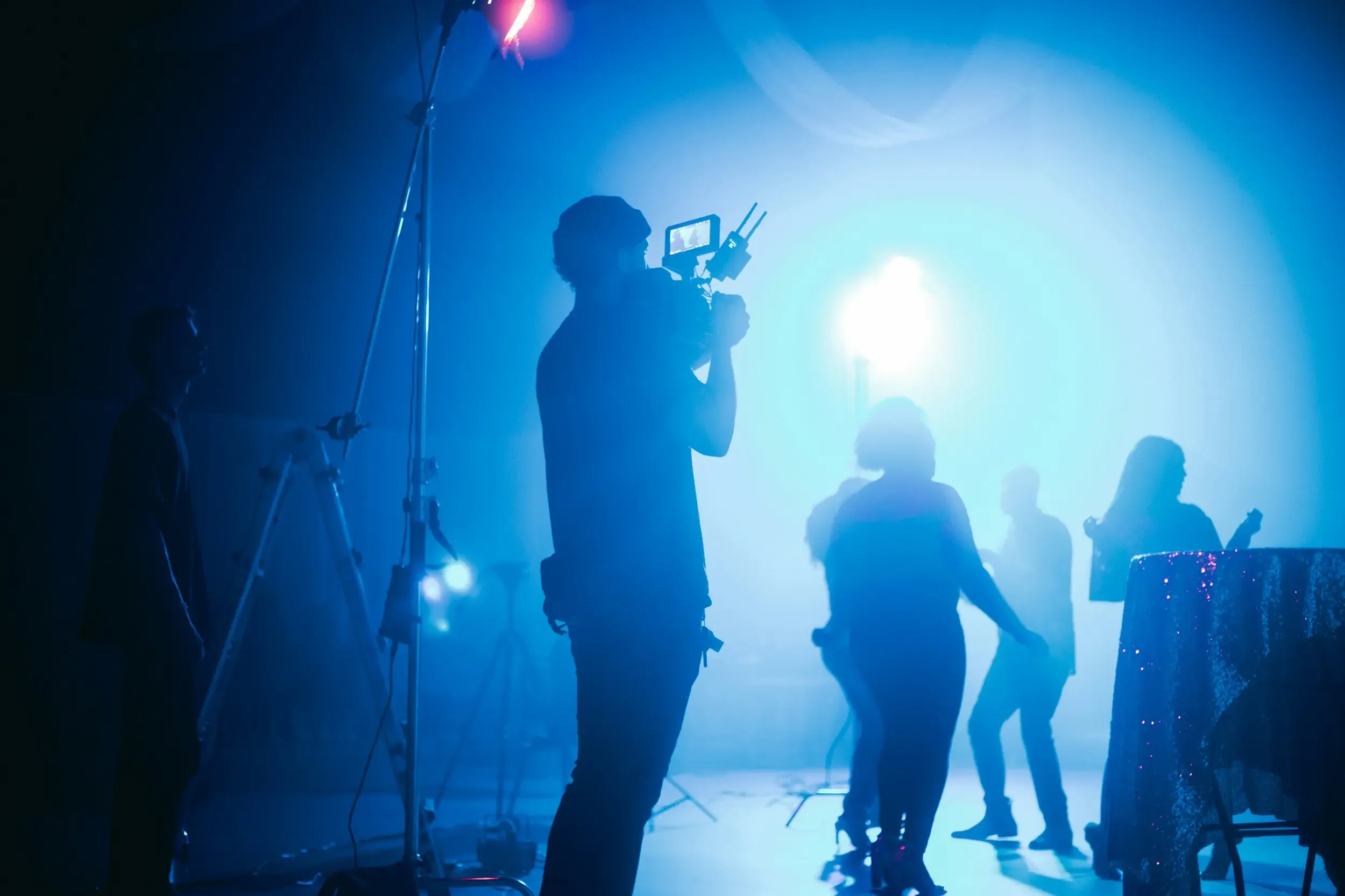 Ein Kameramann im Einsatz am stimmungsvoll beleuchteten Set während eines praxisnahen Workshops für Kameraführung, Video-Training und Filmberatung durch Blackship Studios.