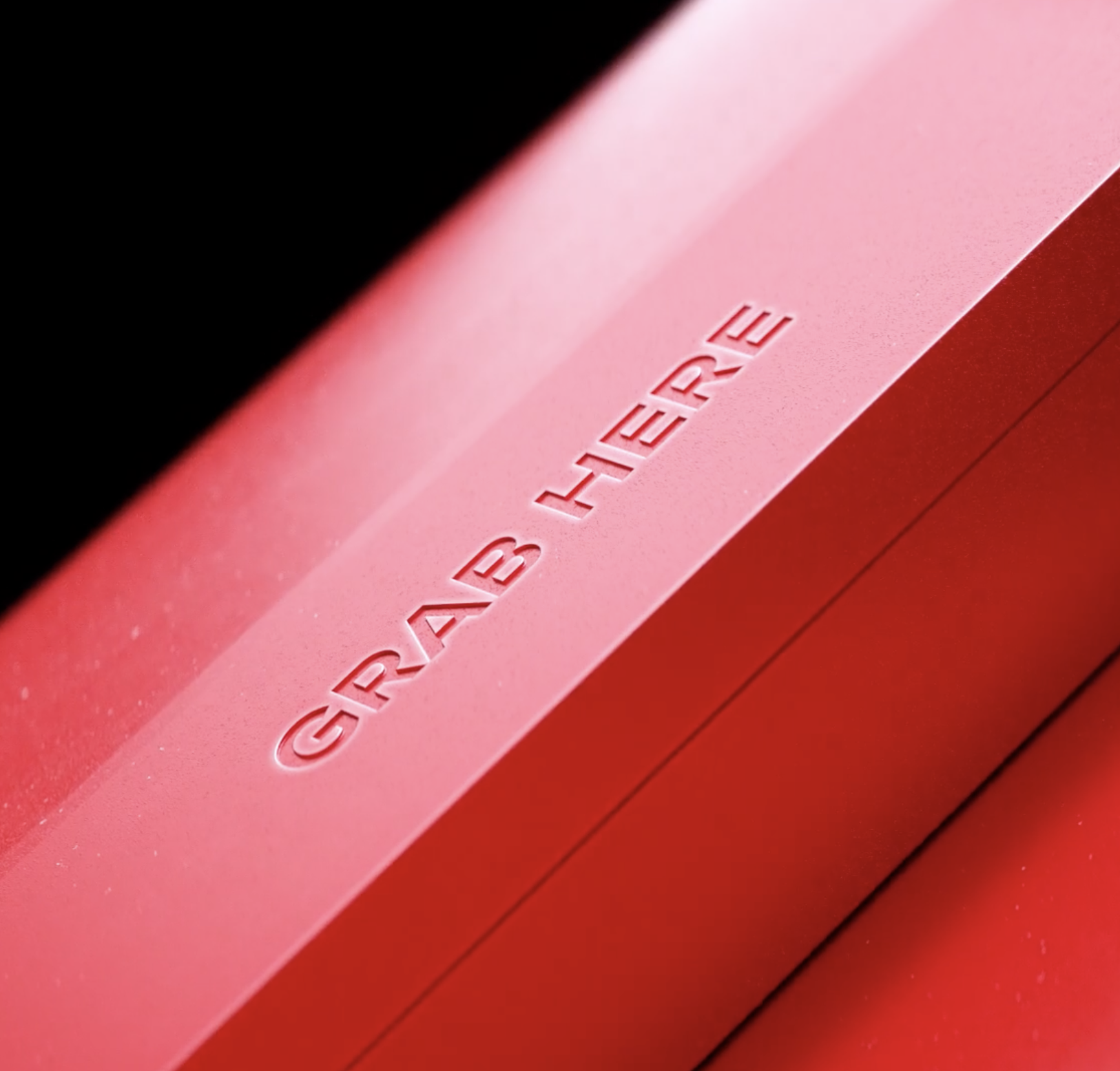 Close-up of a red, warning triangle with the word 'GRABHERE' embossed in the center.