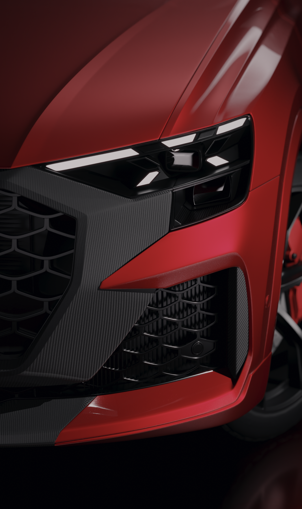 Close-up of a red Audi Q5 sports car front, highlighting the sleek headlight, black grille, and carbon fiber detailing.