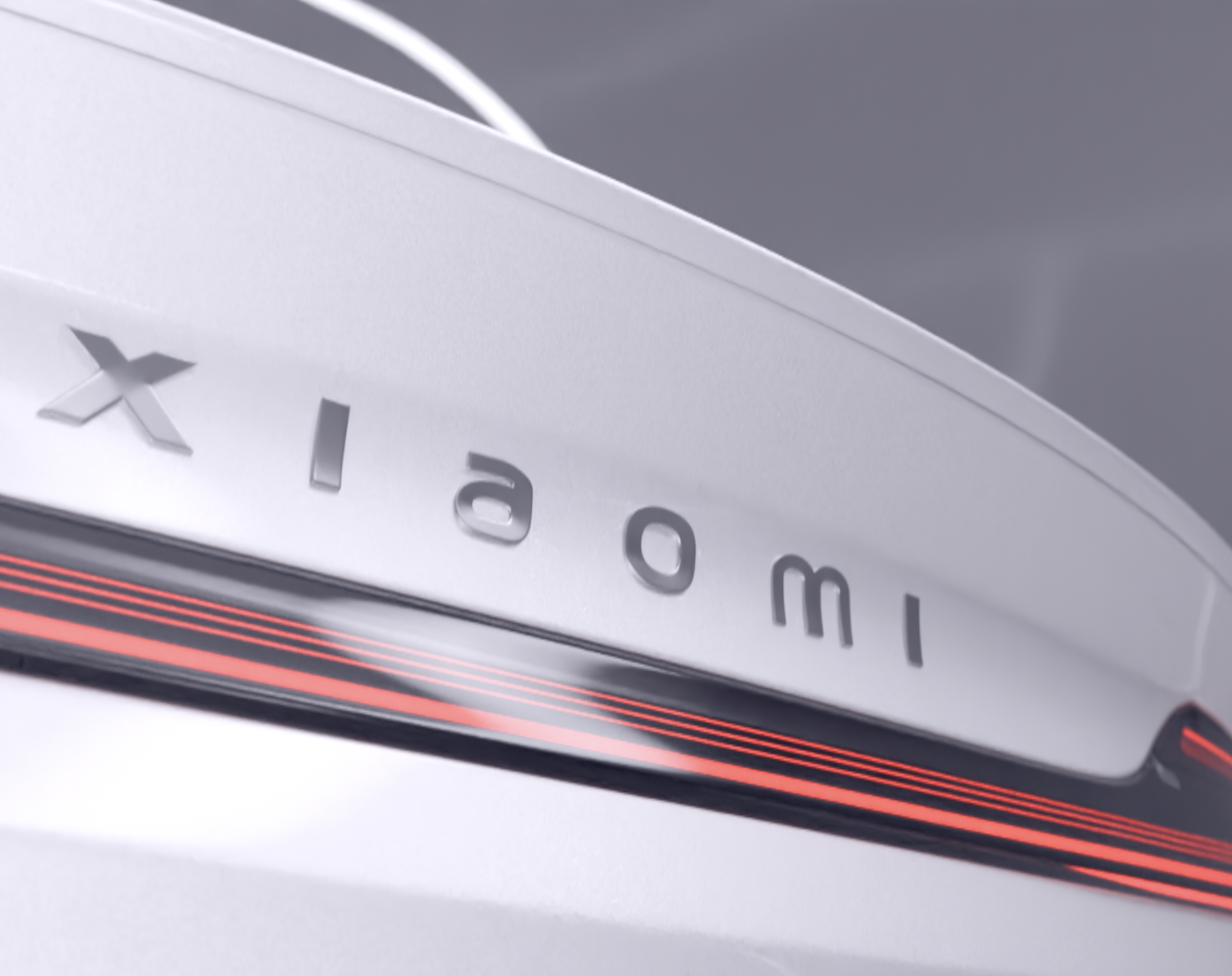 Close-up of a white electronic device with the mark 'Xiaomi' engraved on it, featuring a sleek design with red accents.