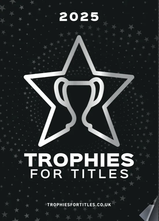 A promotional graphic for awards or trophies for titles, featuring a silver star outline with a trophy cup inside, set against a black background with small star patterns, and the text '2025 Trophies for Titles' with the website 'trophiesfortitles.co.uk'.