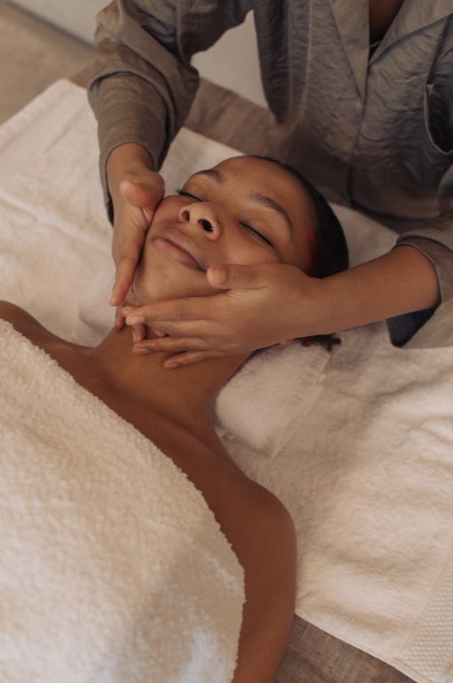 Person receiving a facial massage at a spa or massage therapy session.