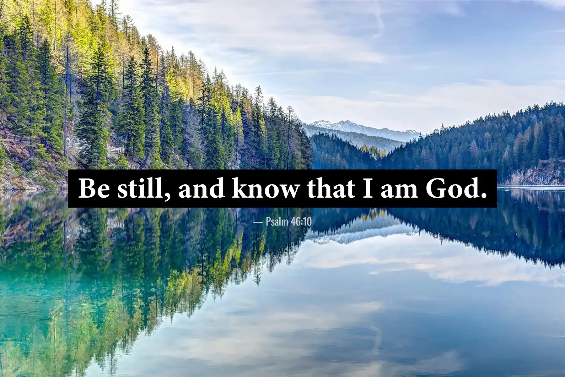 Psalm 46:10 Bible verse reflected in a serene forest lake surrounded by mountains.