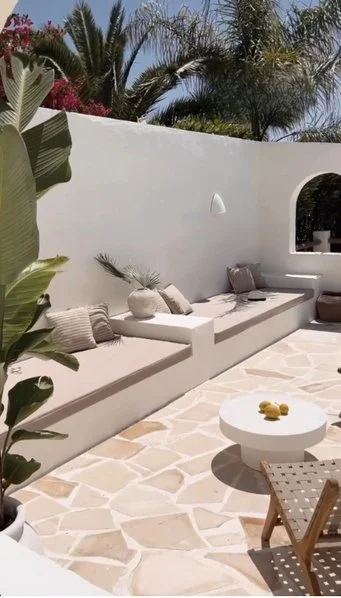 Douceur de vivre avec cette terrasse aux banquettes maçonnées sur mesure en Siporex - © burkhartinteriors