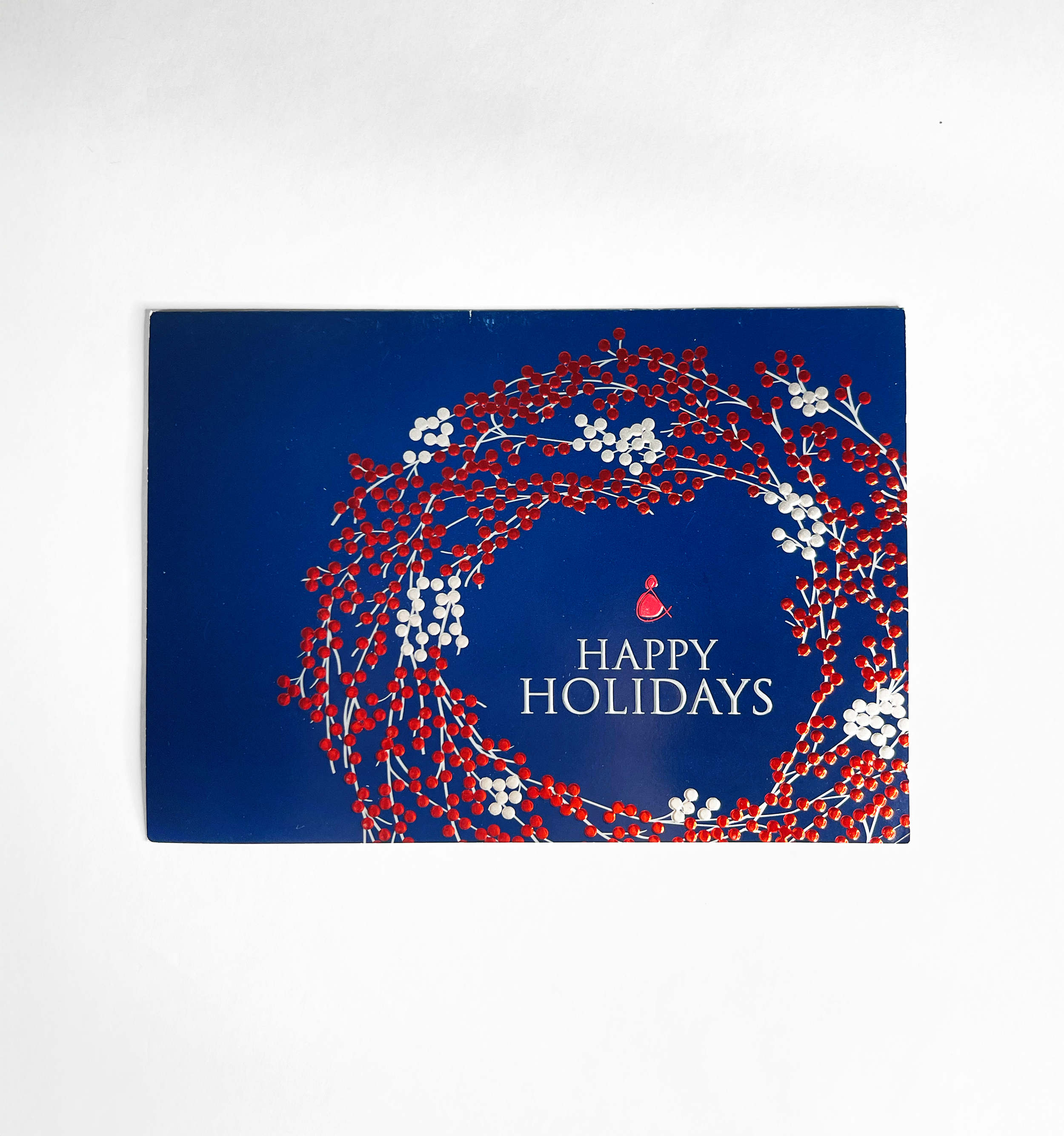 Holiday greeting card with red and white berry wreath and the message 'HAPPY HOLIDAYS' on a dark blue background.