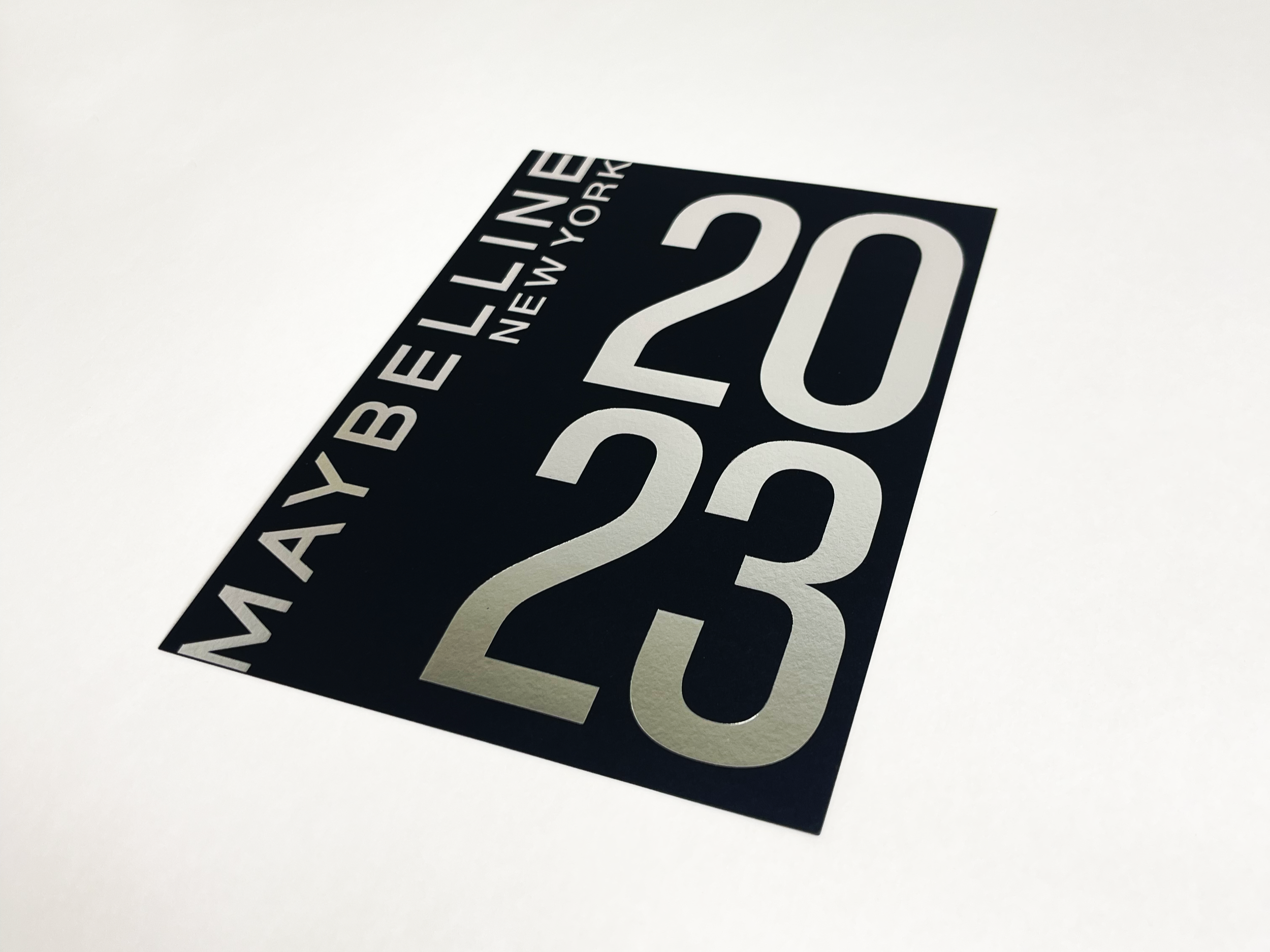 A black sticker with silver text displaying the date May 23, 2020, and the words 'YELINE NEW YORK'.