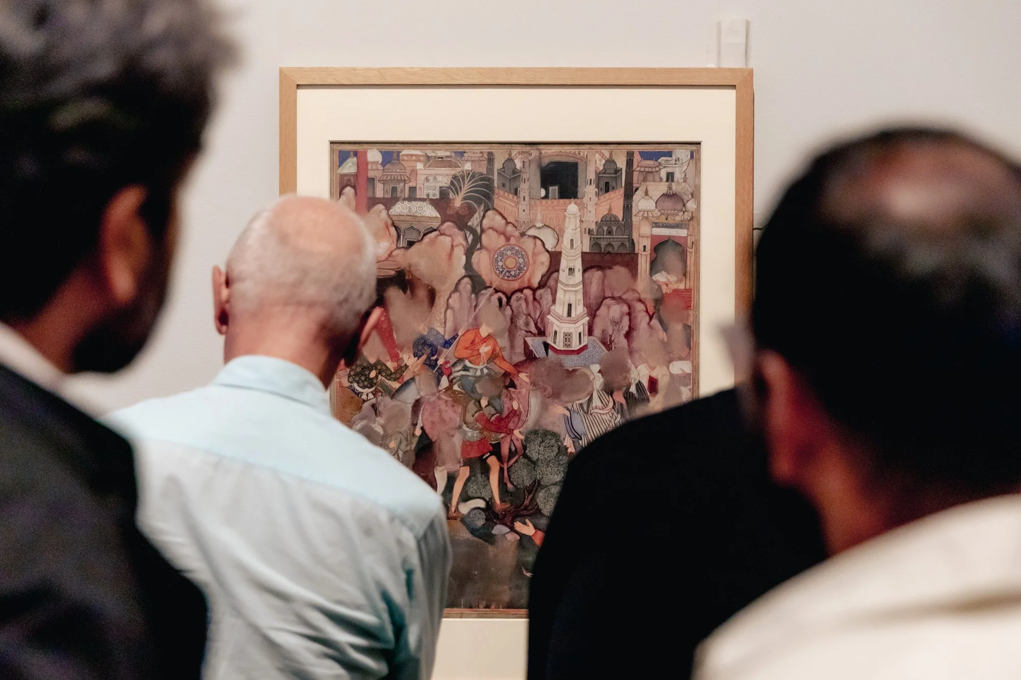 People viewing a painting in an art gallery.