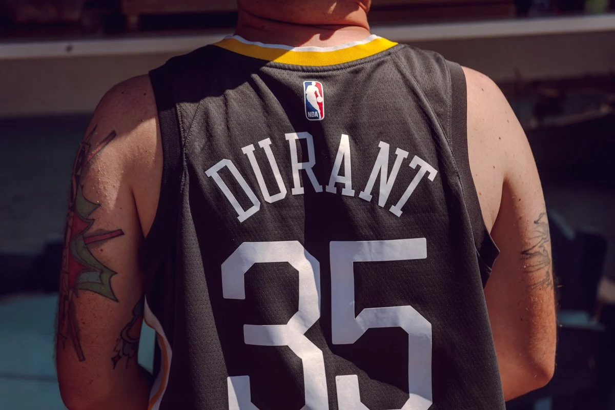 Close-up of a person wearing a black NBA basketball jersey with the name 'Durant' and the number '35' printed on the back.