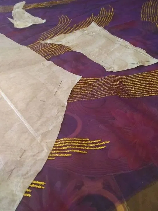 Technical pattern placement on luxury purple and gold fabric in my Burnham-on-Crouch studio, preparing for the precision hand-cutting of a bespoke Maid of Honour gown.